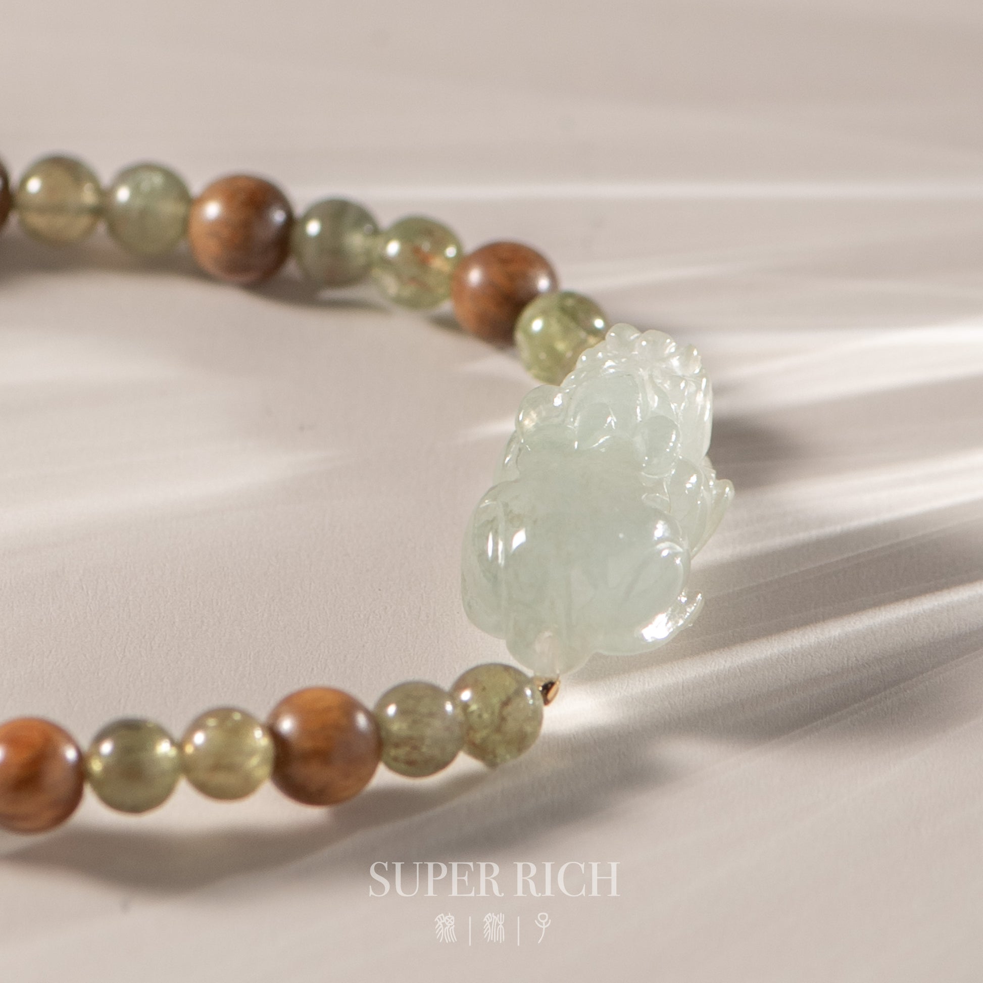 Beaded bracelet with a large green stone on a neutral background, featuring the brand 'Super Rich'.