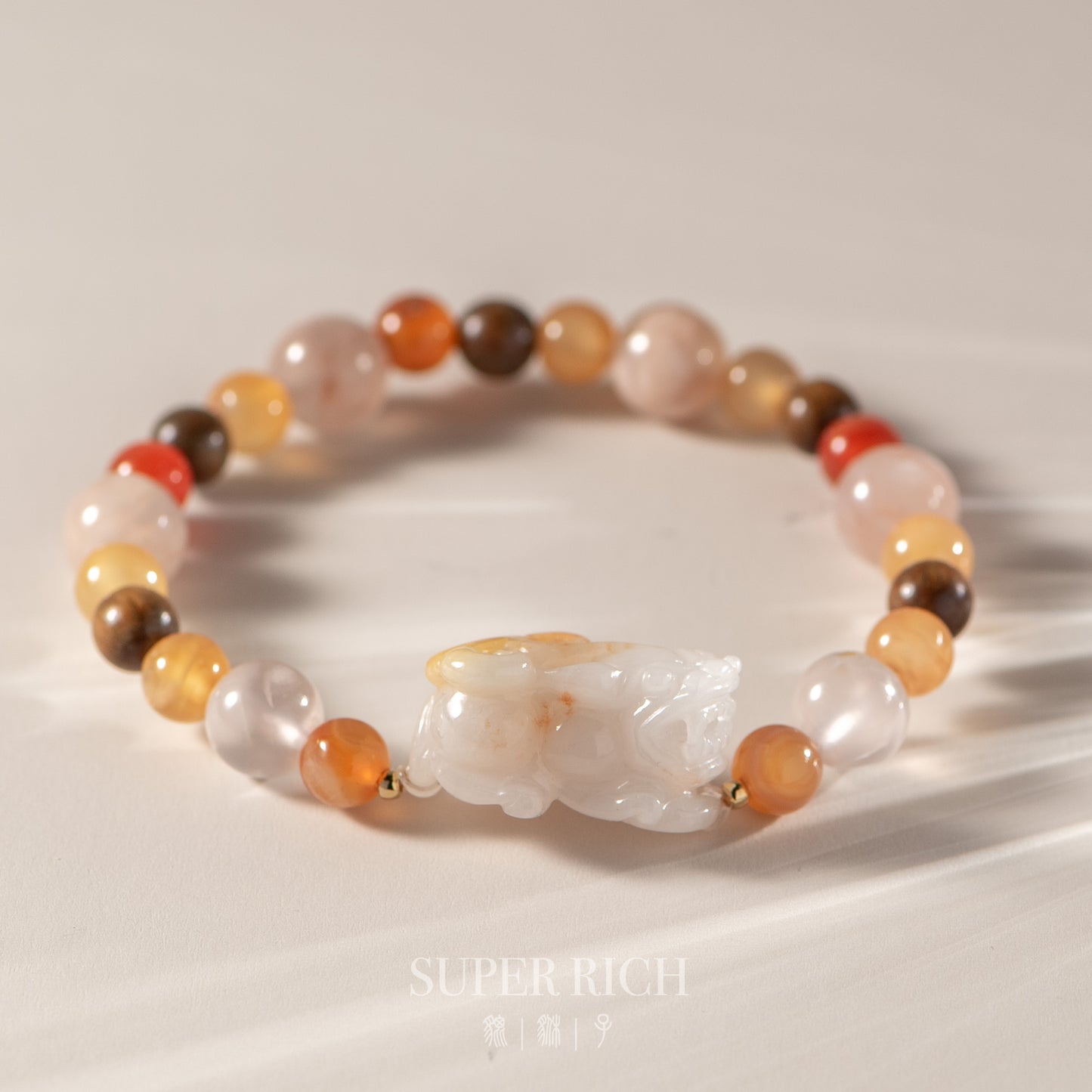 Multicolored beaded bracelet with a central white stone on a light background, featuring the brand 'Super Rich'.