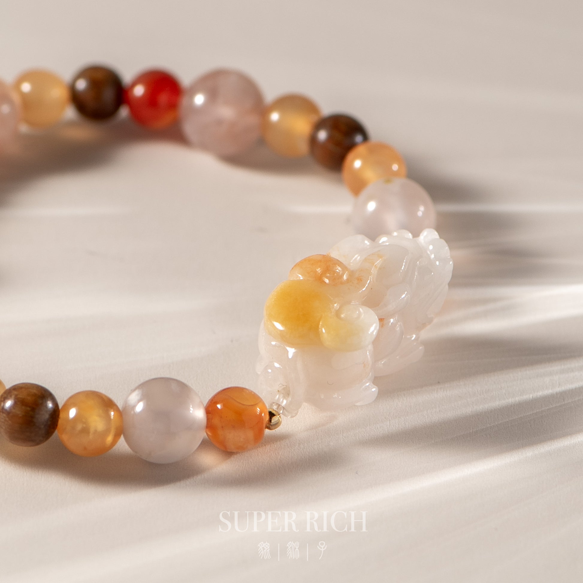 Multicolored beaded bracelet with a white stone charm on a neutral background, featuring the brand 'Super Rich'.