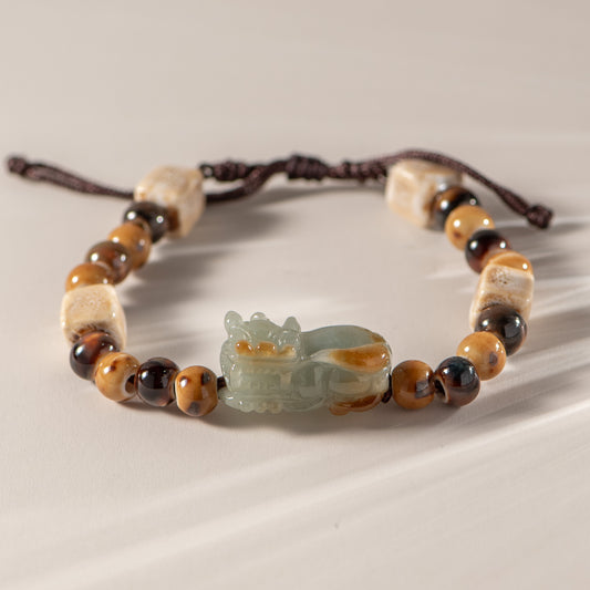 Bracelet with beads and a jade charm on a neutral background