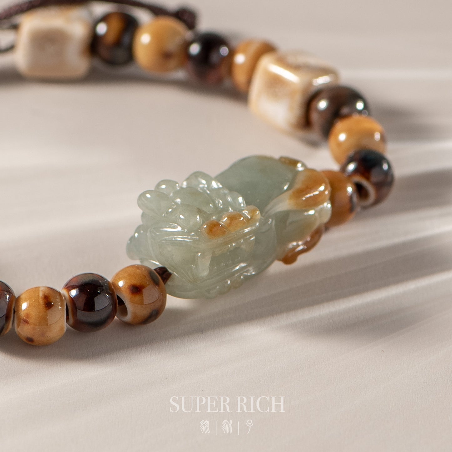 Necklace with jade pendant and beaded chain on a light background