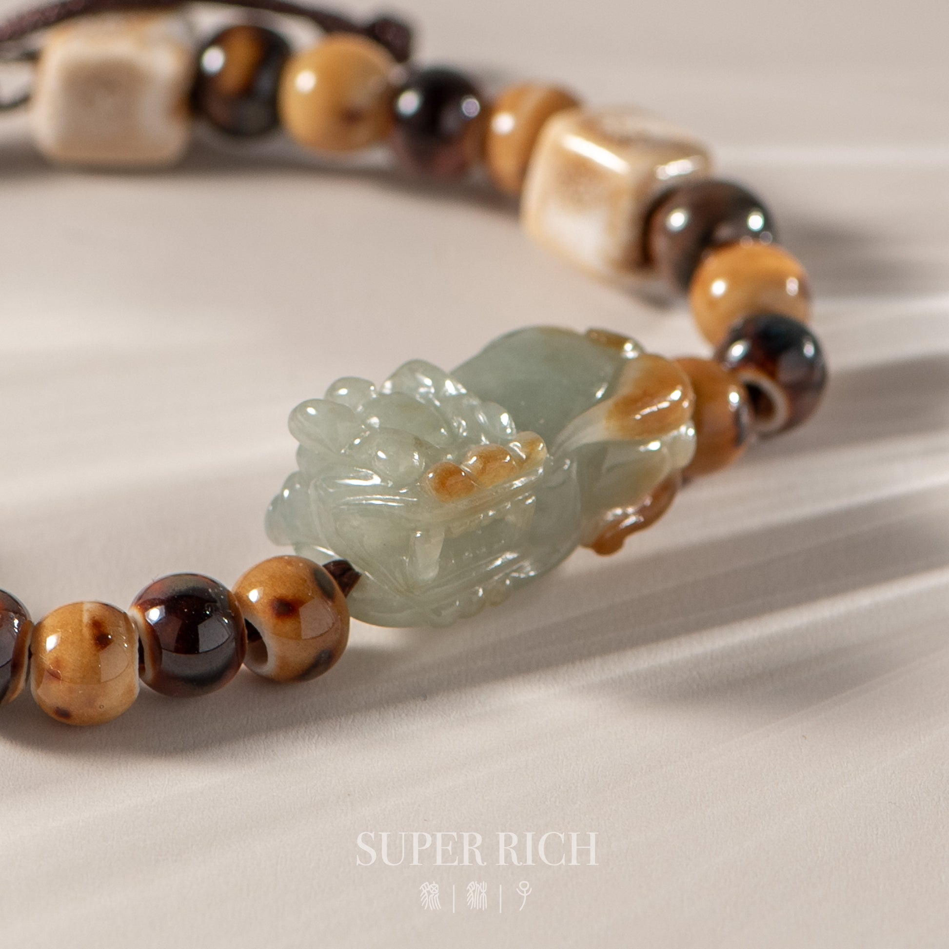 Necklace with jade pendant and beaded chain on a light background