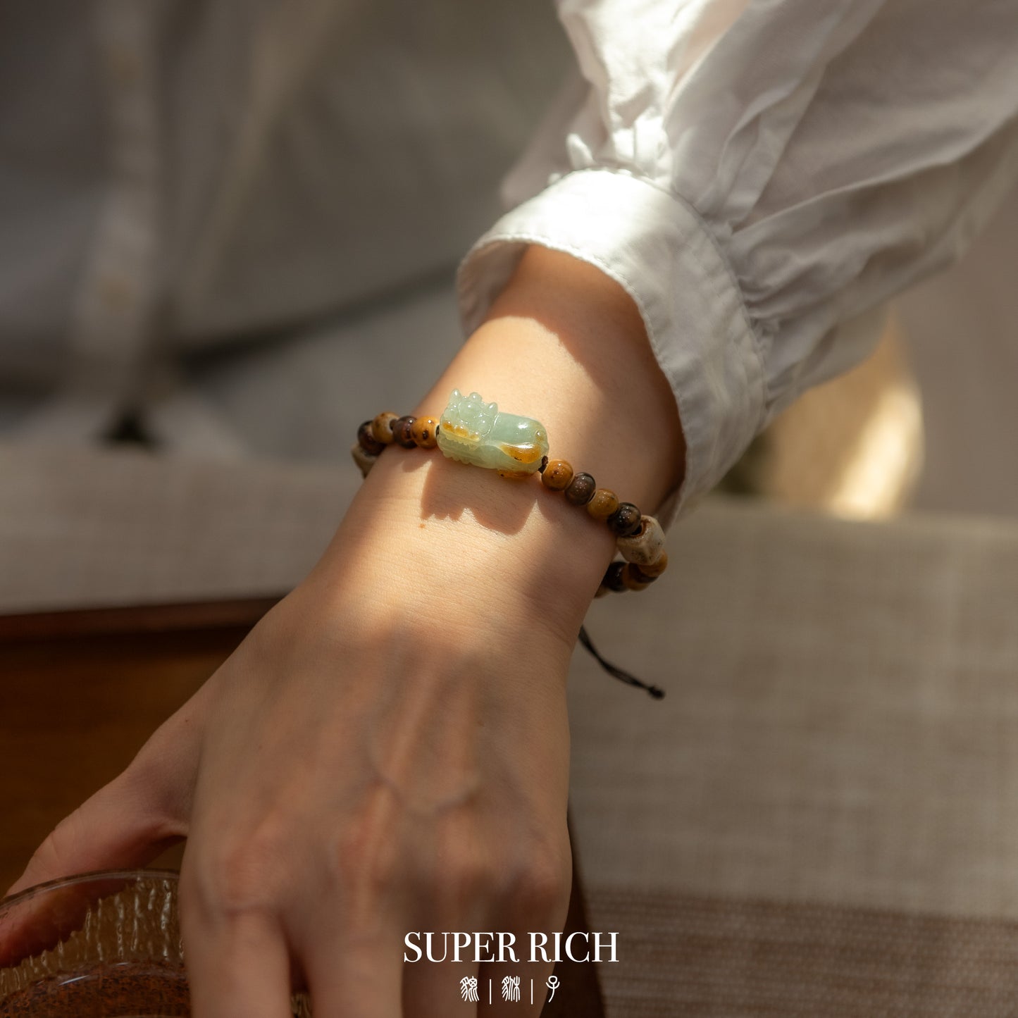 Hand wearing a beaded bracelet with a blurred background