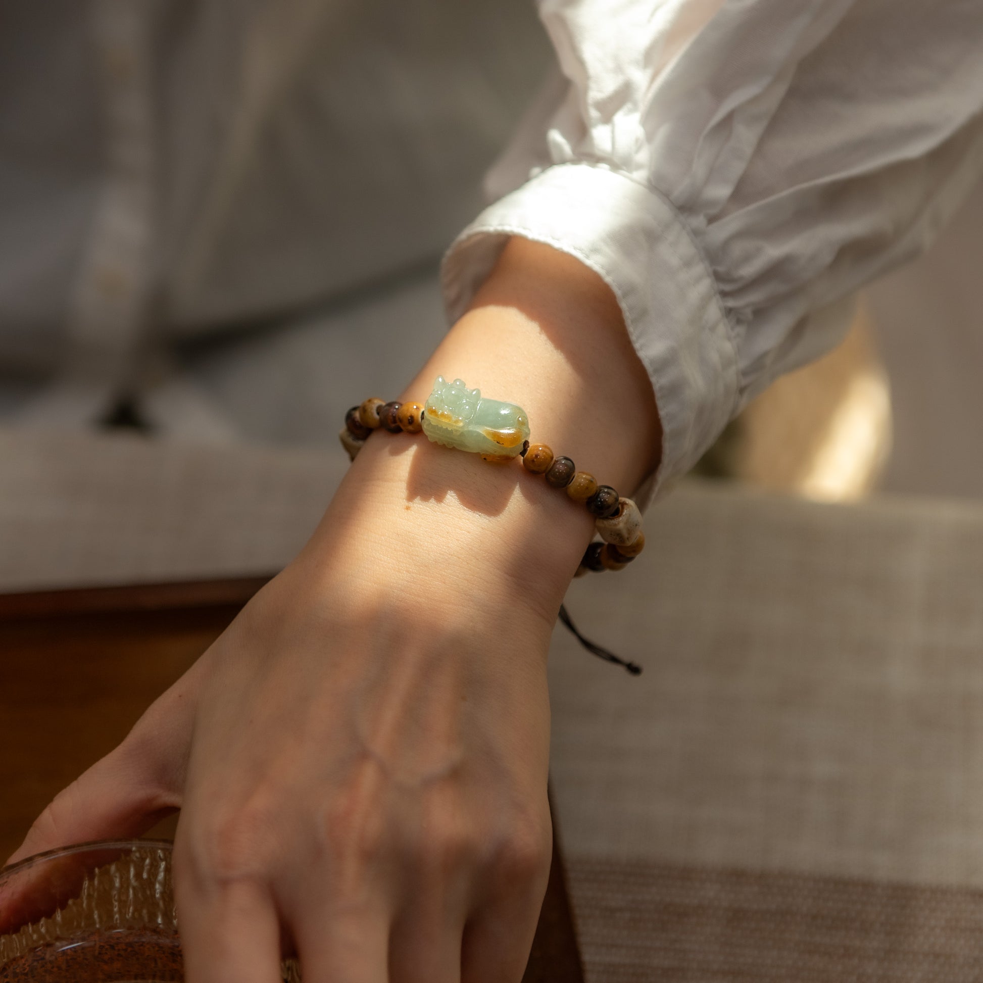 Close-up of a hand wearing a beaded bracelet with a blurred background