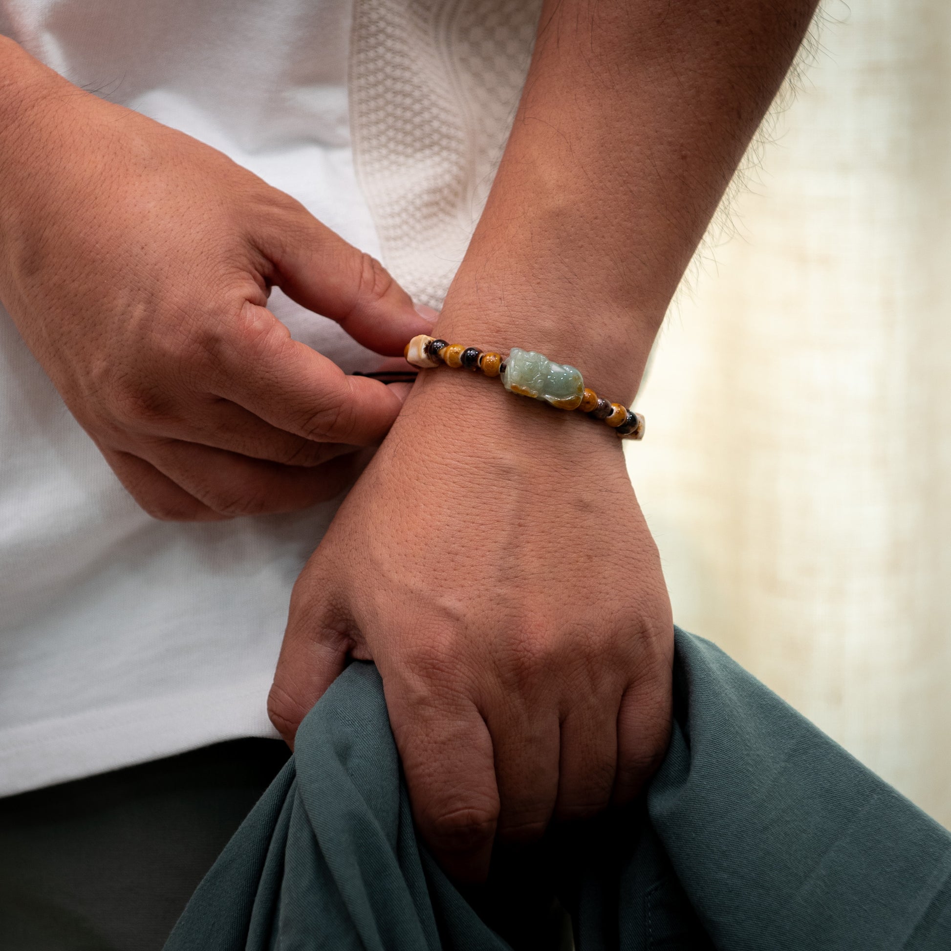 Person adjusting a bracelet on their wrist with a blurred background