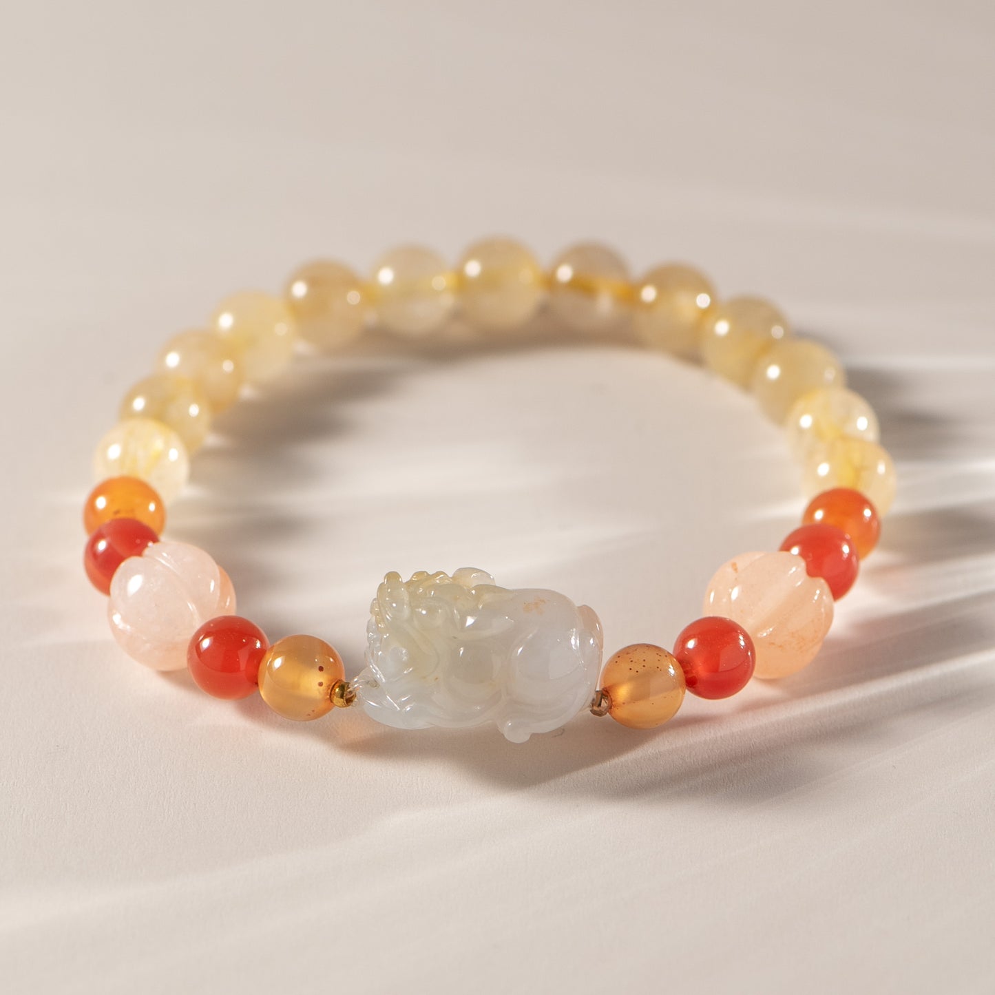 Beaded bracelet with a central stone on a neutral background