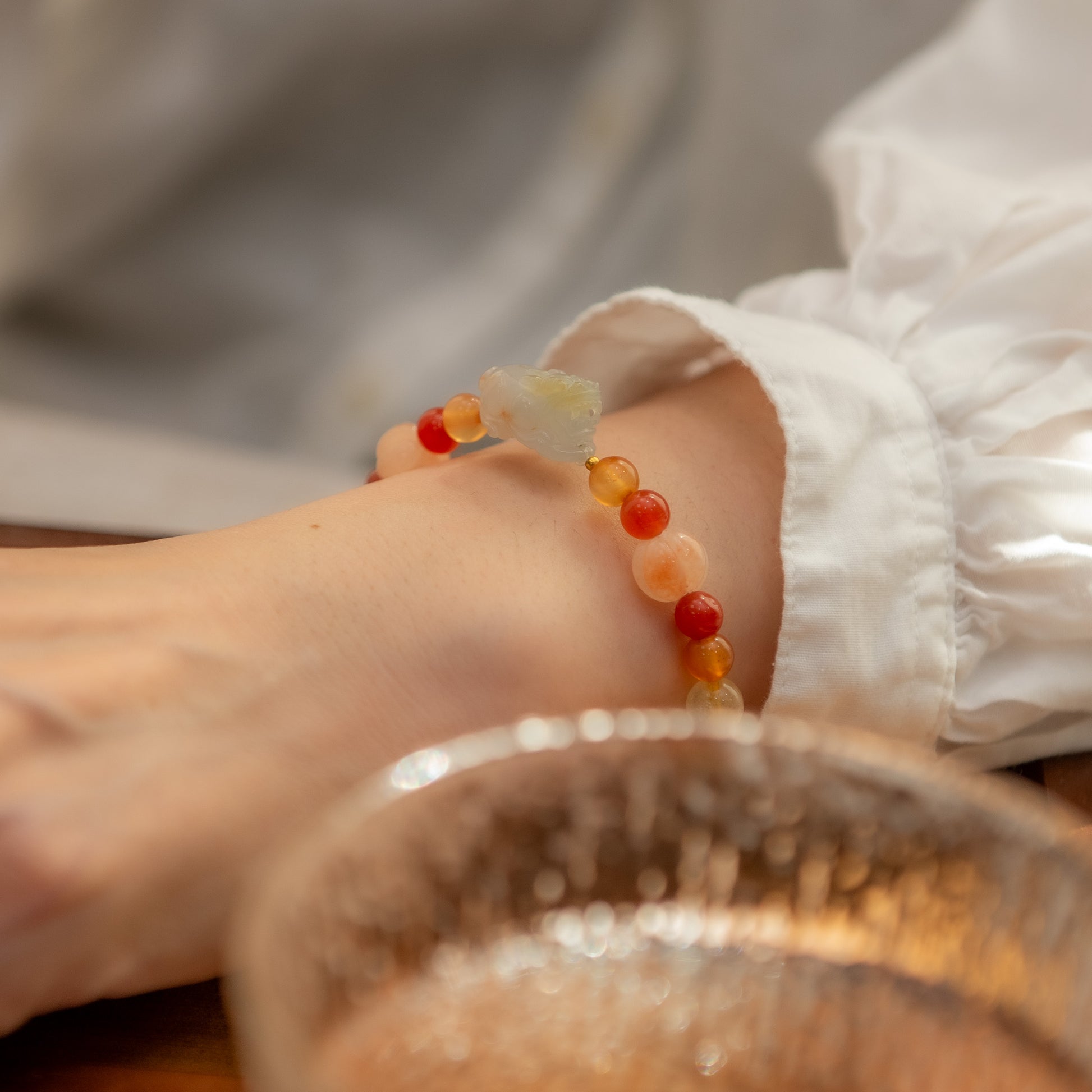 Close-up of a foot wearing a colorful beaded anklet with a blurred background