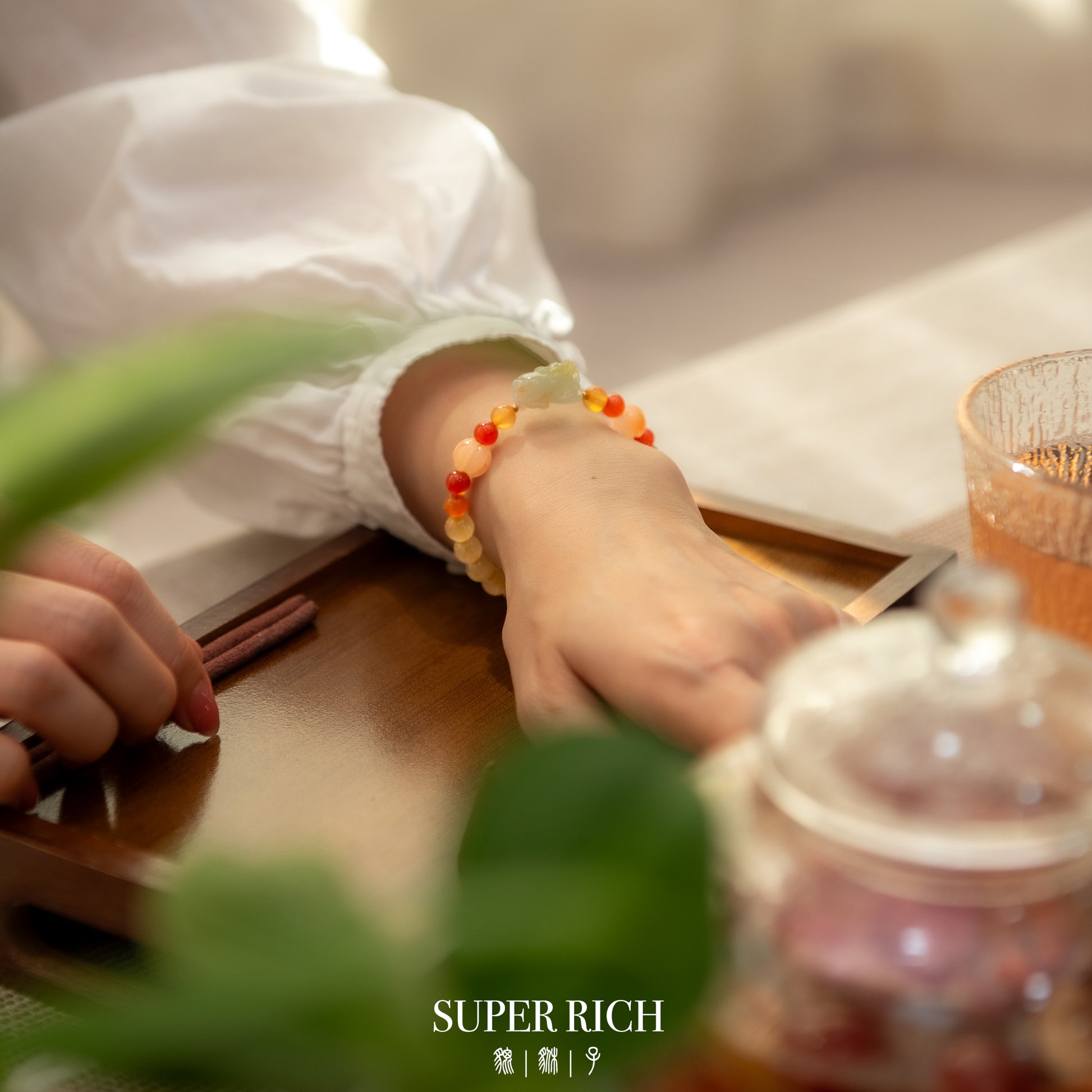 Person wearing a colorful beaded bracelet with a blurred background
