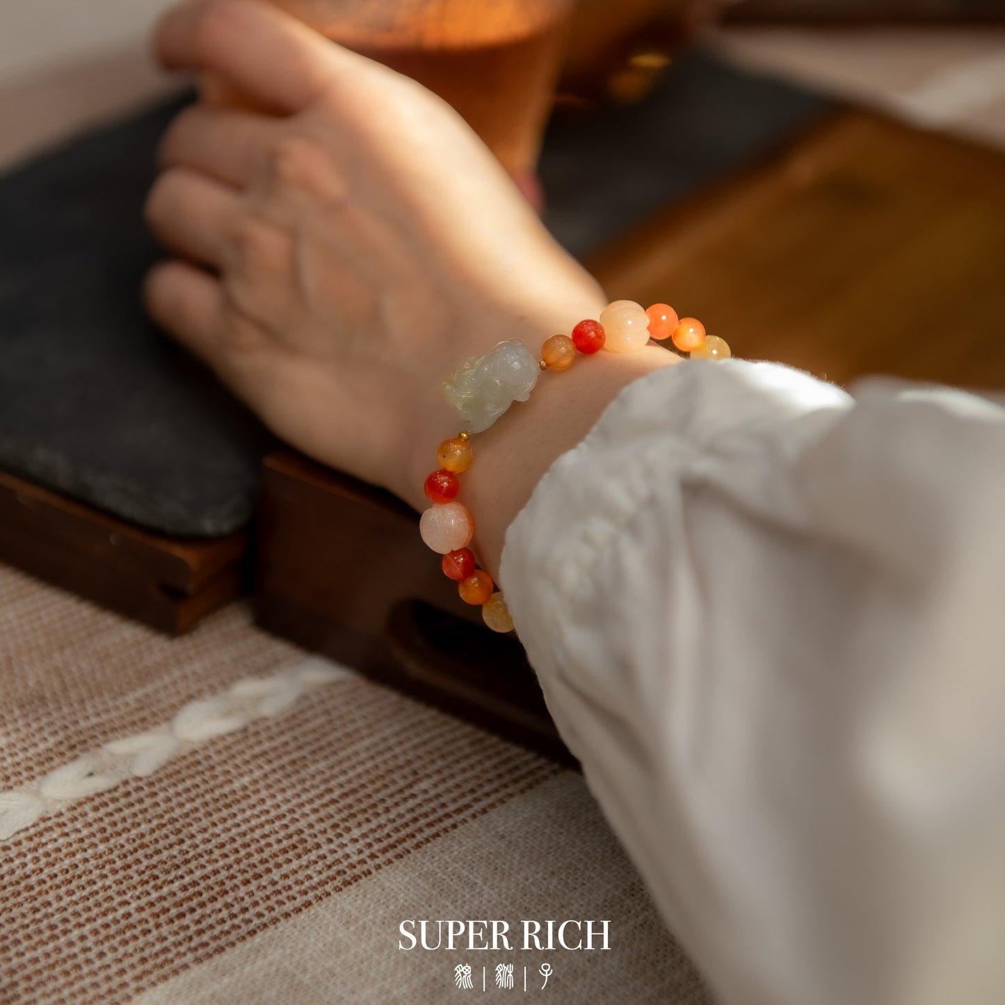 Close-up of a hand wearing a colorful beaded bracelet with a blurred background