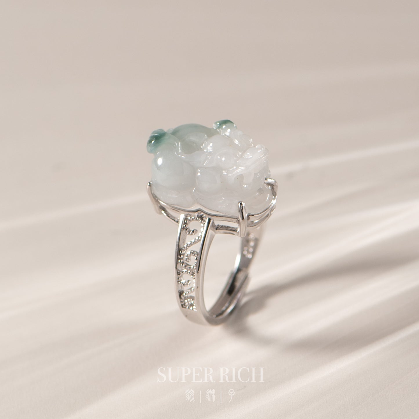 Silver ring with a large green gemstone on a beige background