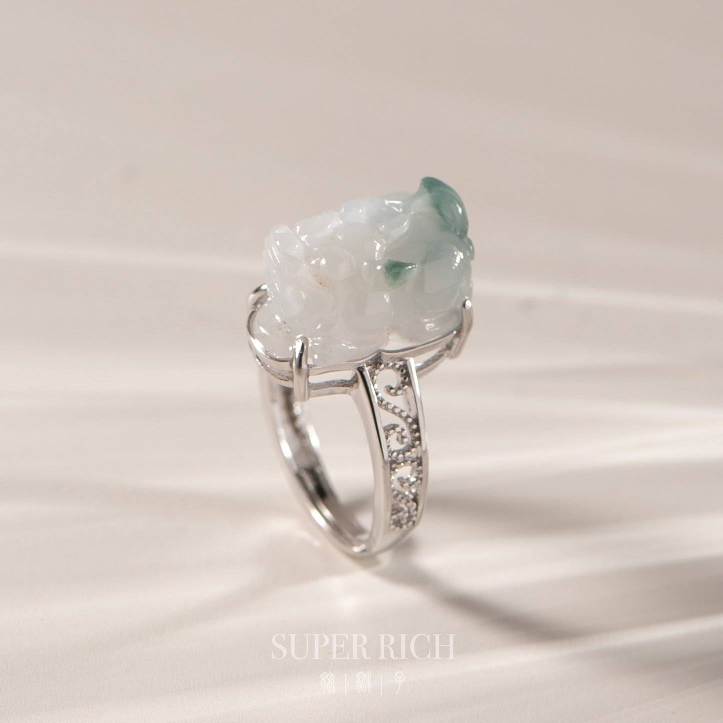 Silver ring with a large green gemstone on a light background