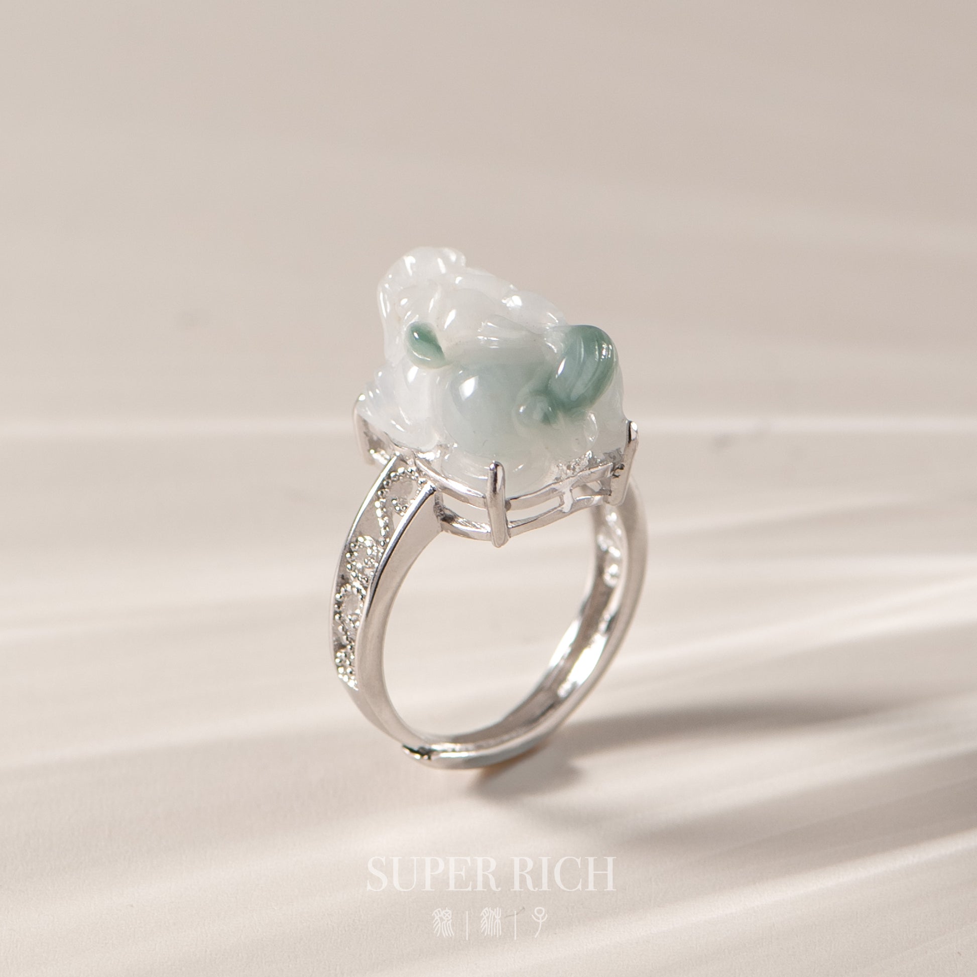 Silver ring with a green gemstone on a light background