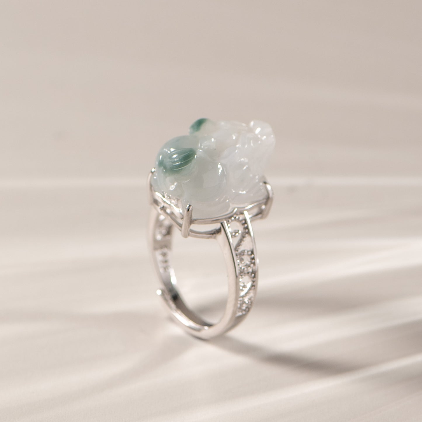 Silver ring with a large green gemstone on a light background