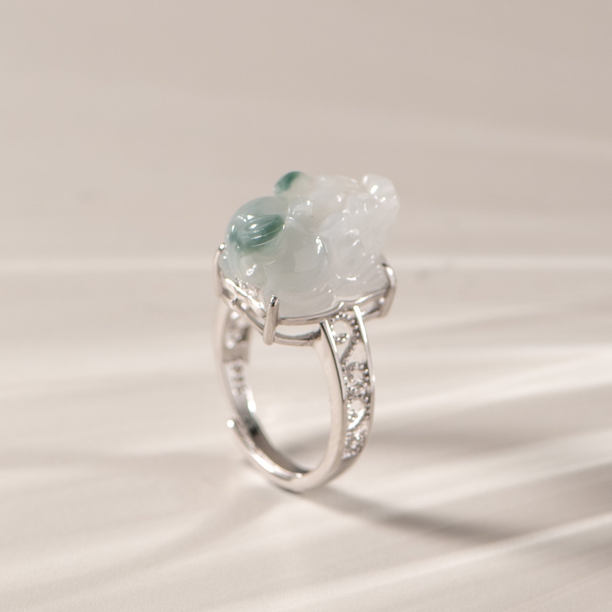 Silver ring with a large green gemstone on a light background