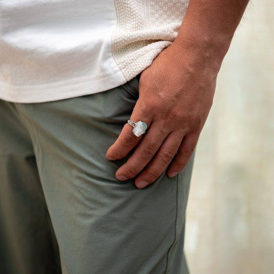 Person wearing a ring with a large stone, holding a white towel.