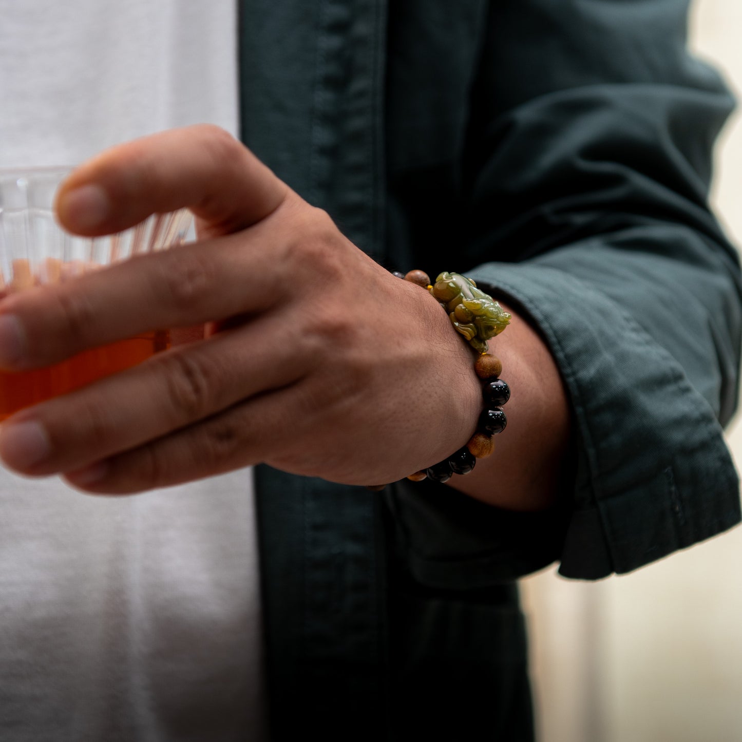 Person wearing a bracelet with beads, holding an orange object.
