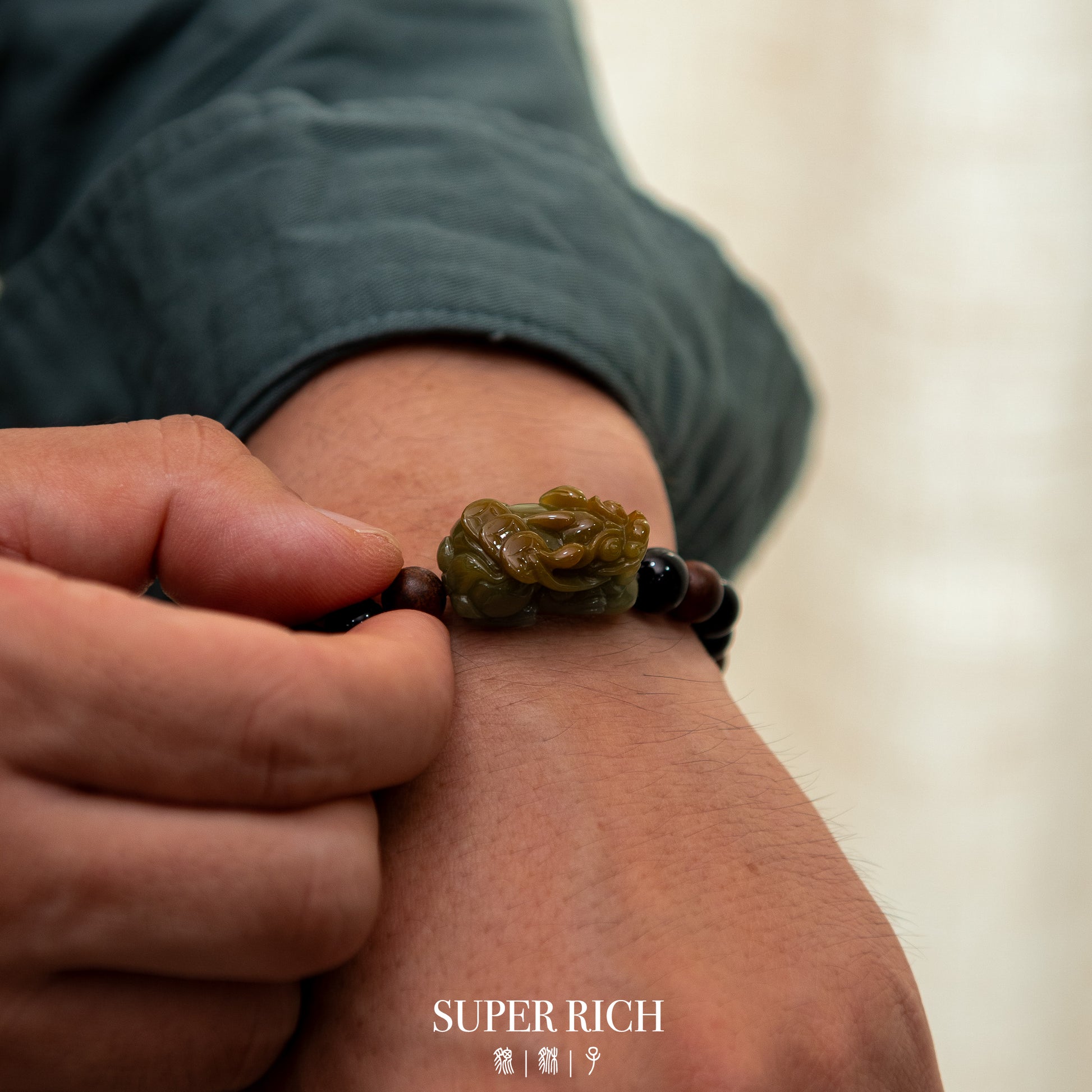 Person wearing a bracelet with a green stone on a blurred background
