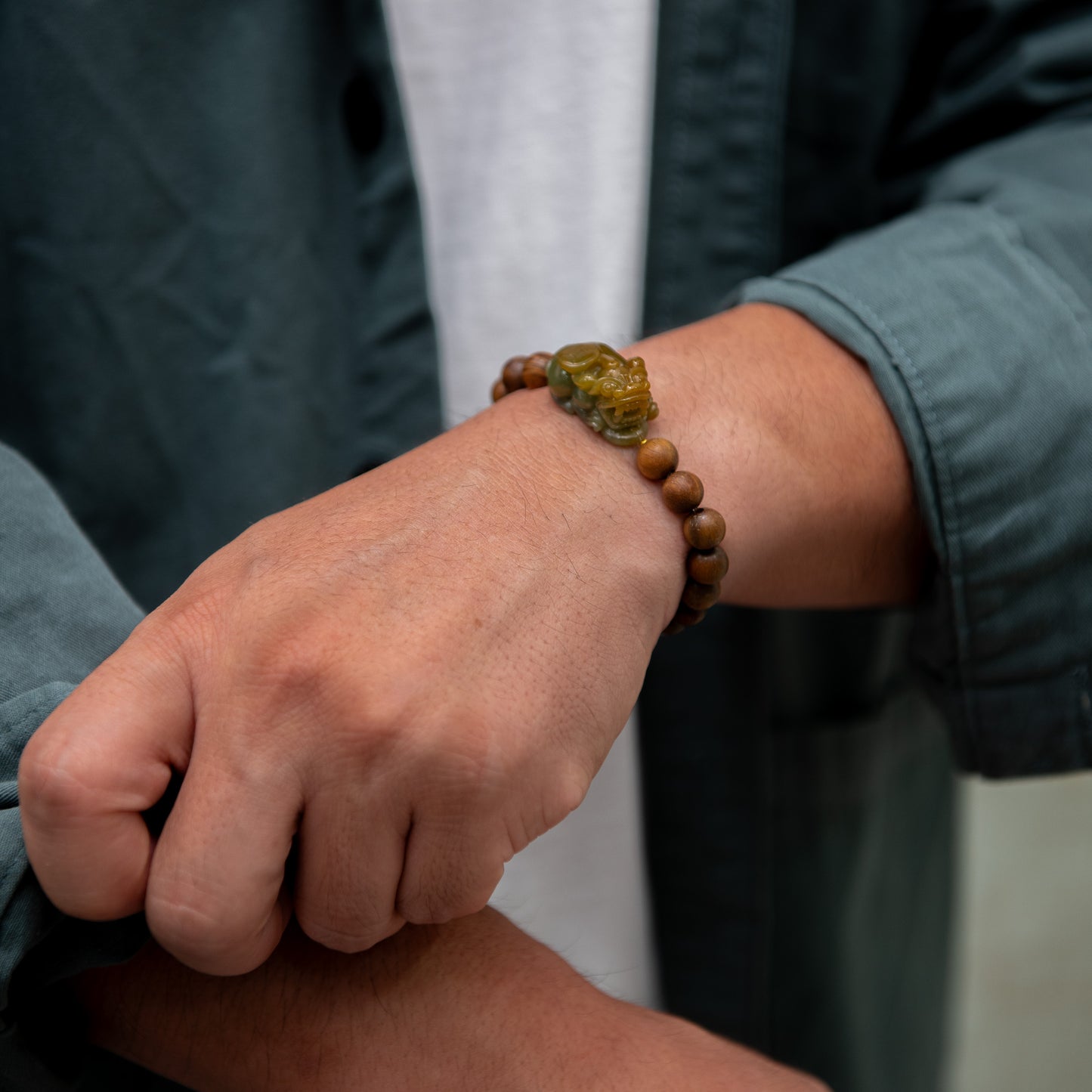 Close-up of a person's wrist wearing a wooden bracelet with a green stone.