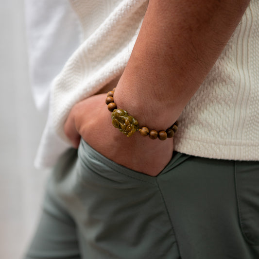 Person wearing a wooden beaded bracelet with a neutral background