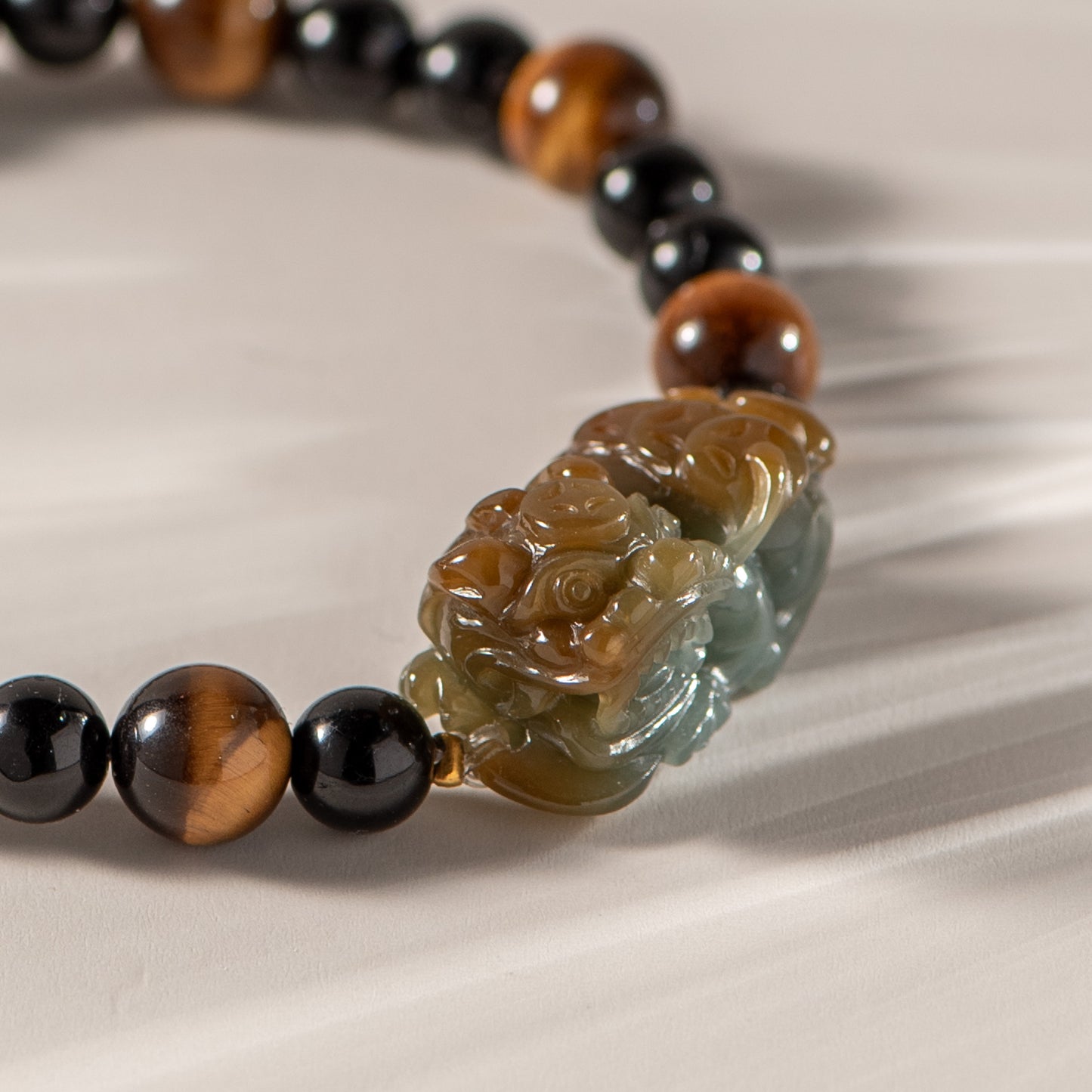 Bracelet with black, brown, and clear beads on a beige background