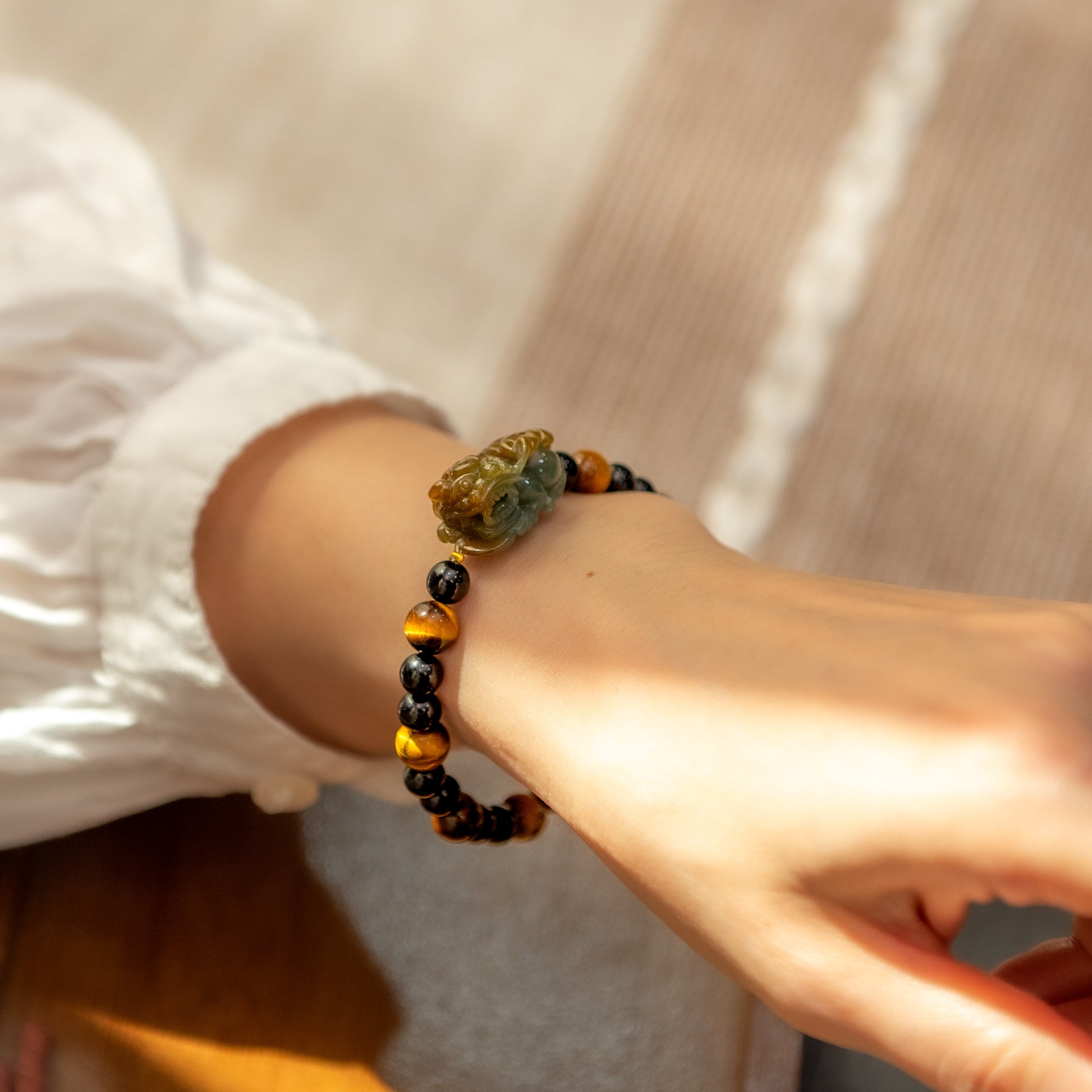 Close-up of a wrist wearing a beaded bracelet with a decorative clasp.