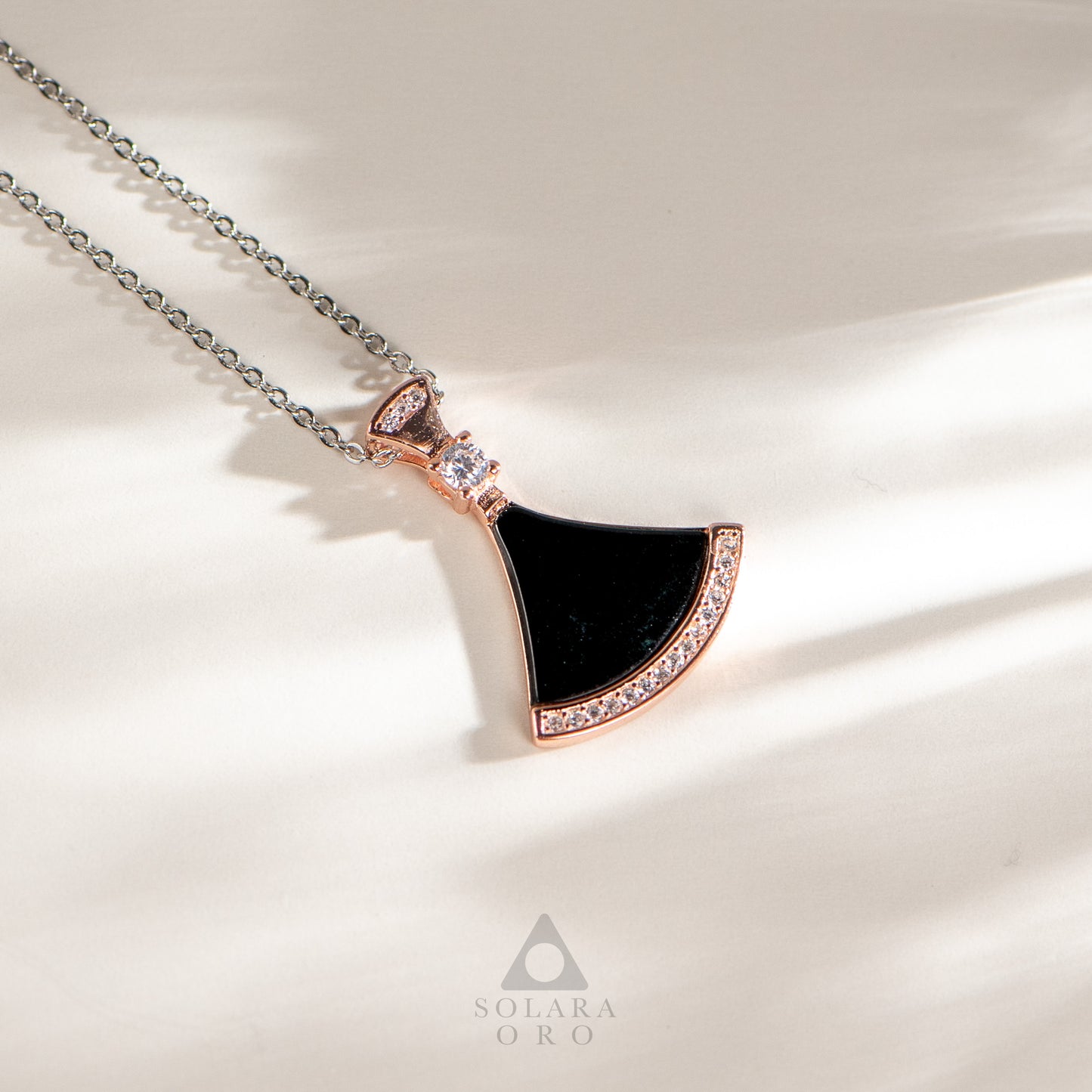 Jewelry necklace with a black pendant on a light background