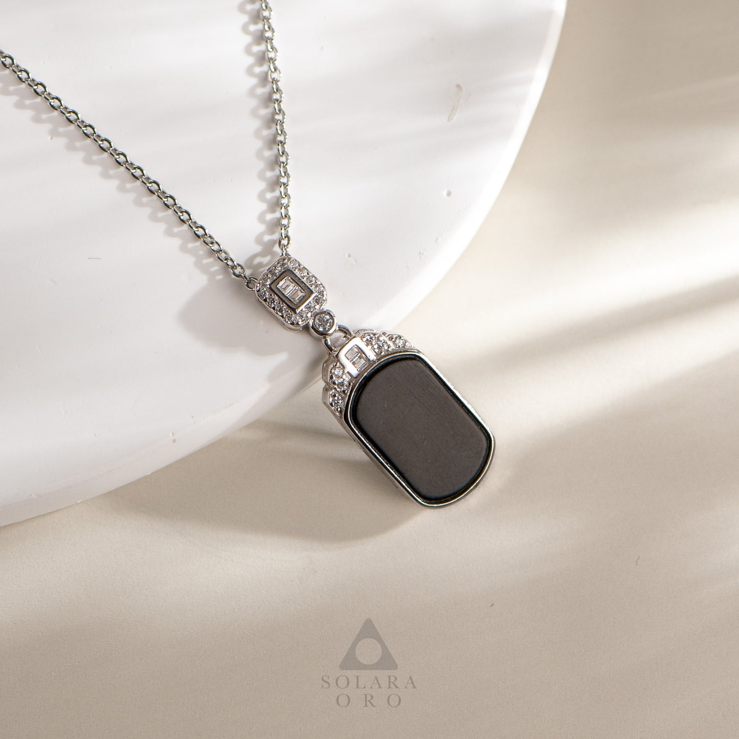 Necklace with a black pendant on a white background, featuring the brand 'Solara Oro'.