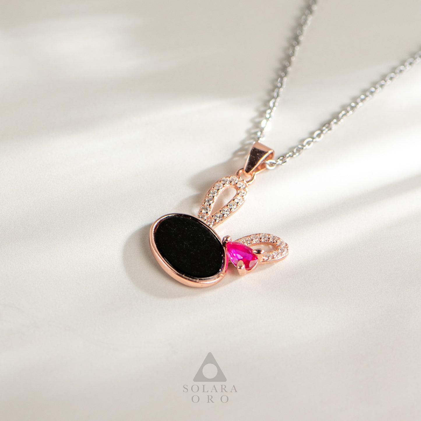 Jewelry necklace with a heart-shaped pendant on a light background, featuring the brand 'Solara Oro'.