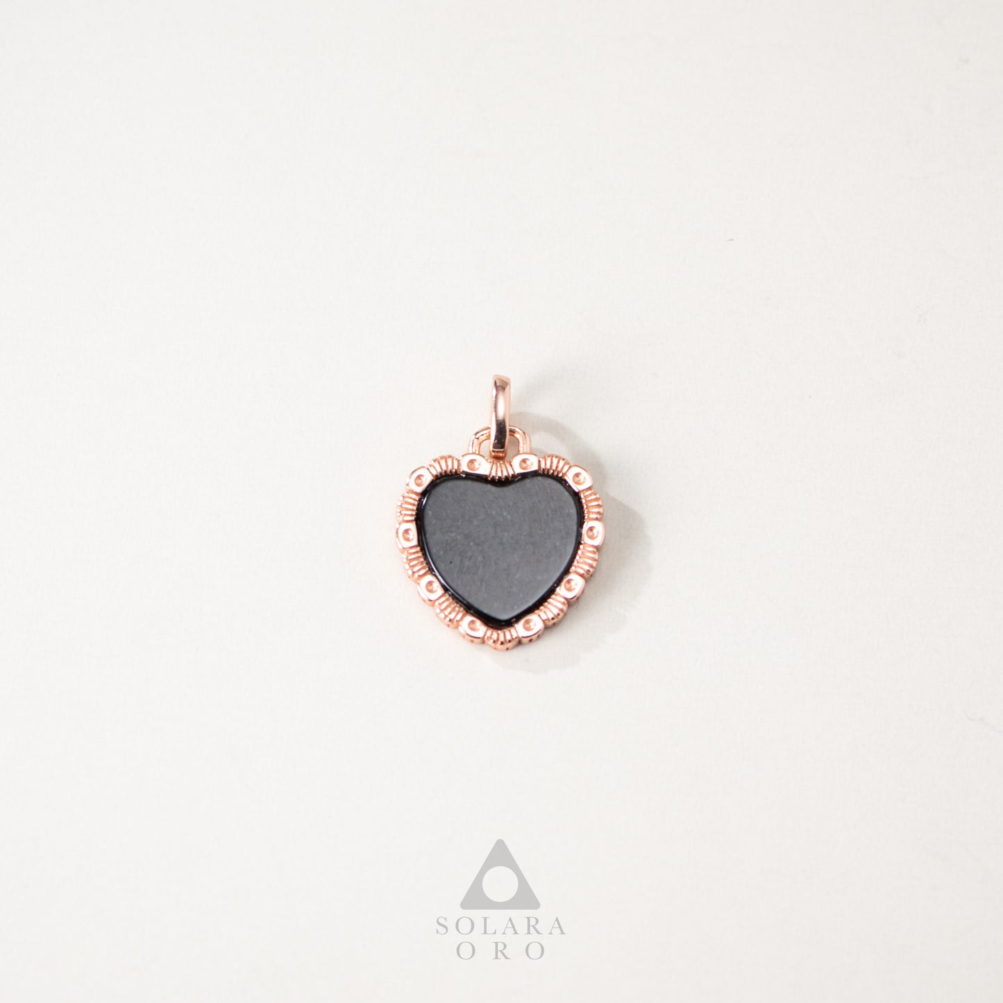 Heart-shaped pendant with rose gold frame on a white background, Solara Oro brand visible.