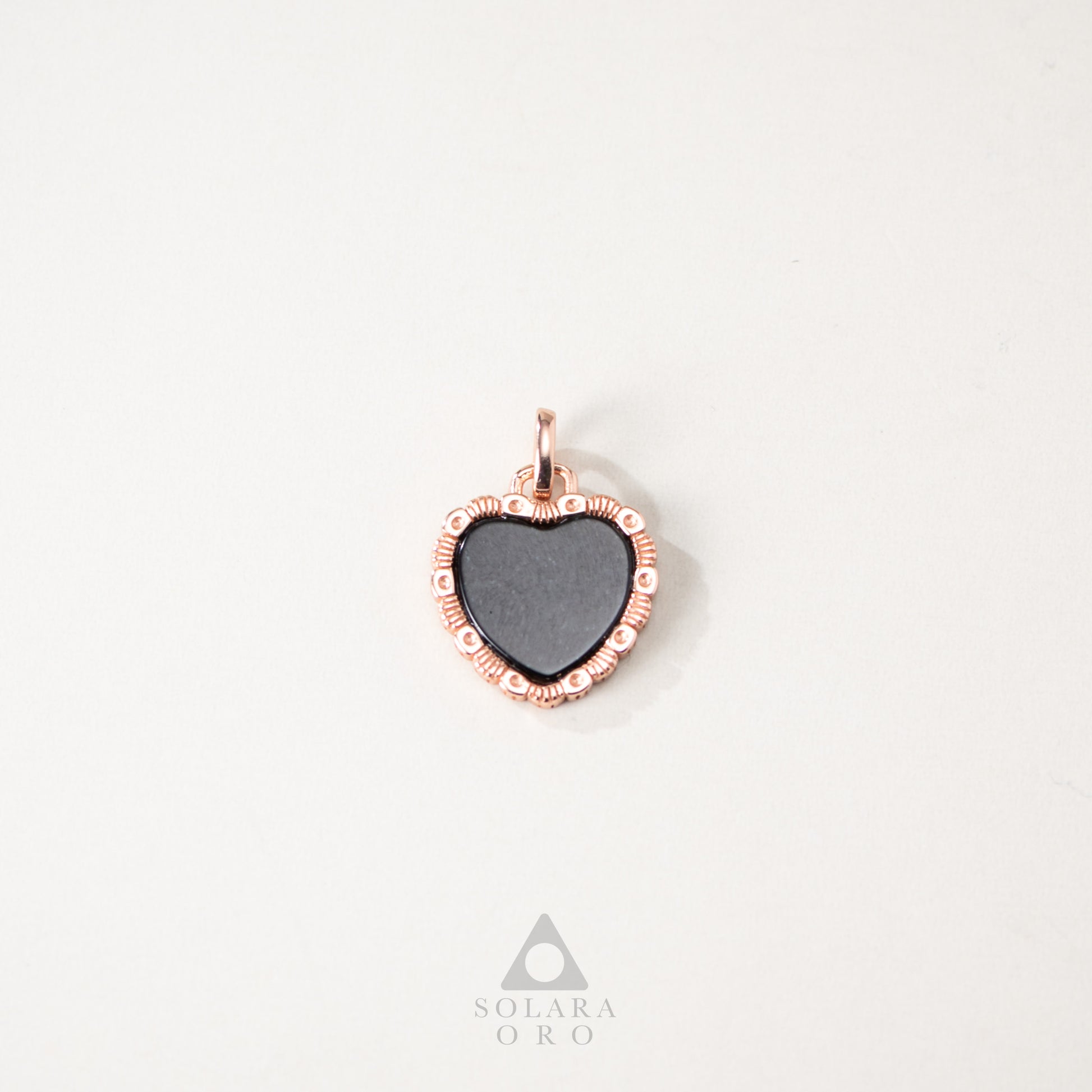 Heart-shaped pendant with rose gold frame on a white background, Solara Oro brand visible.