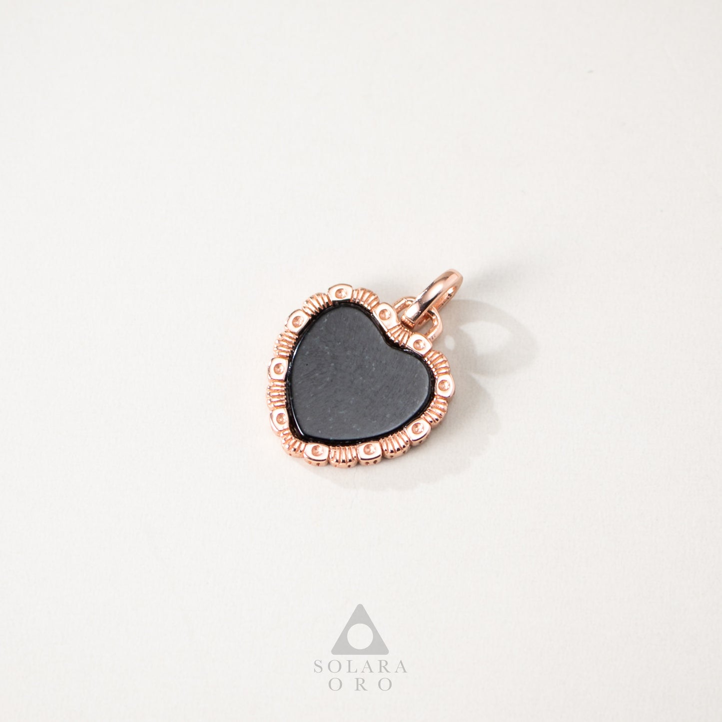 Heart-shaped pendant with rose gold frame on a white background