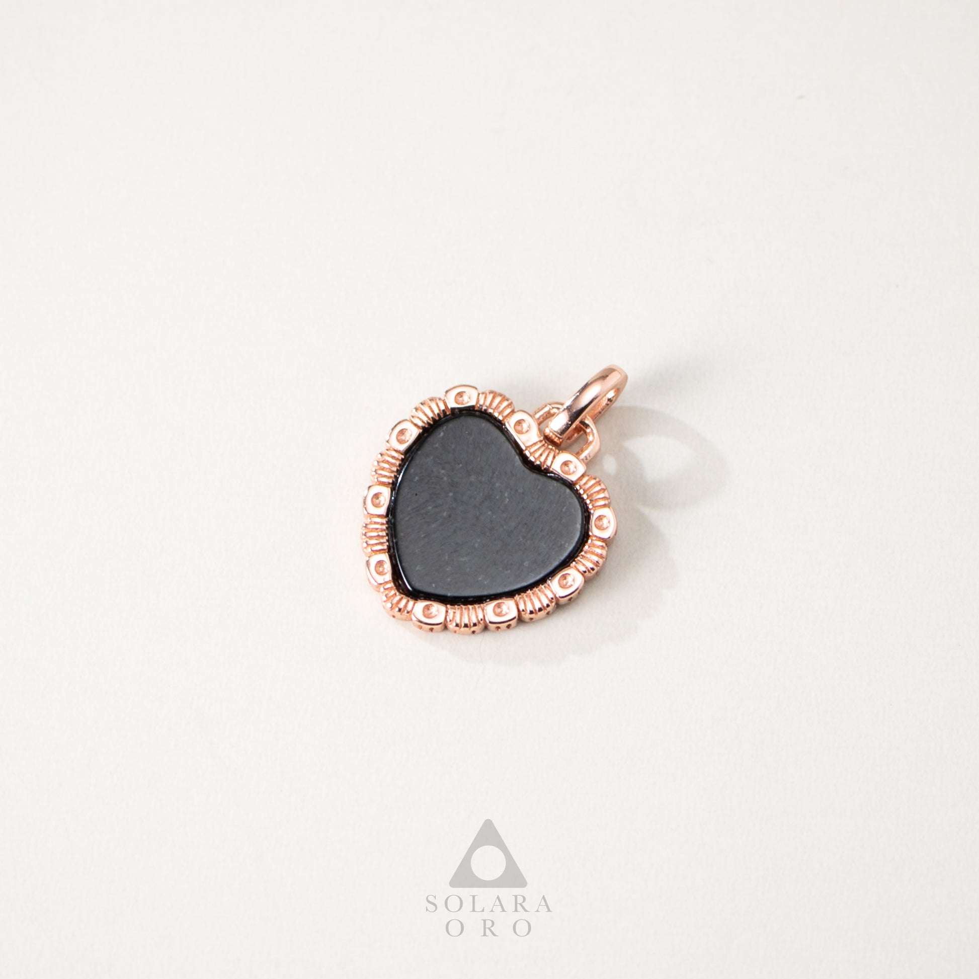 Heart-shaped pendant with rose gold frame on a white background