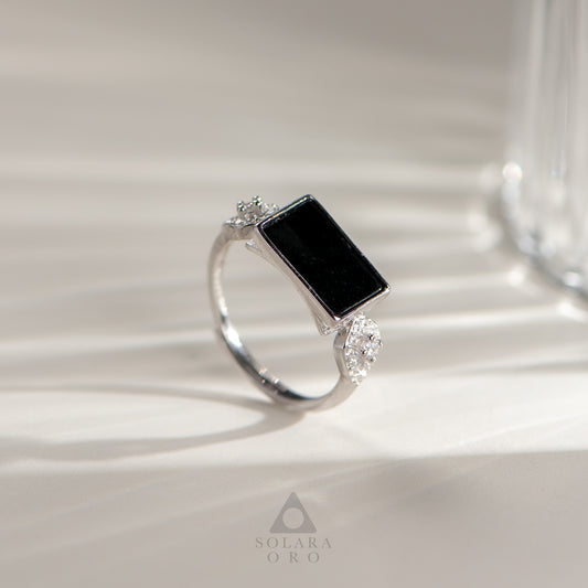 Silver ring with a black gemstone on a light background, featuring the brand 'Soleara Oro'.