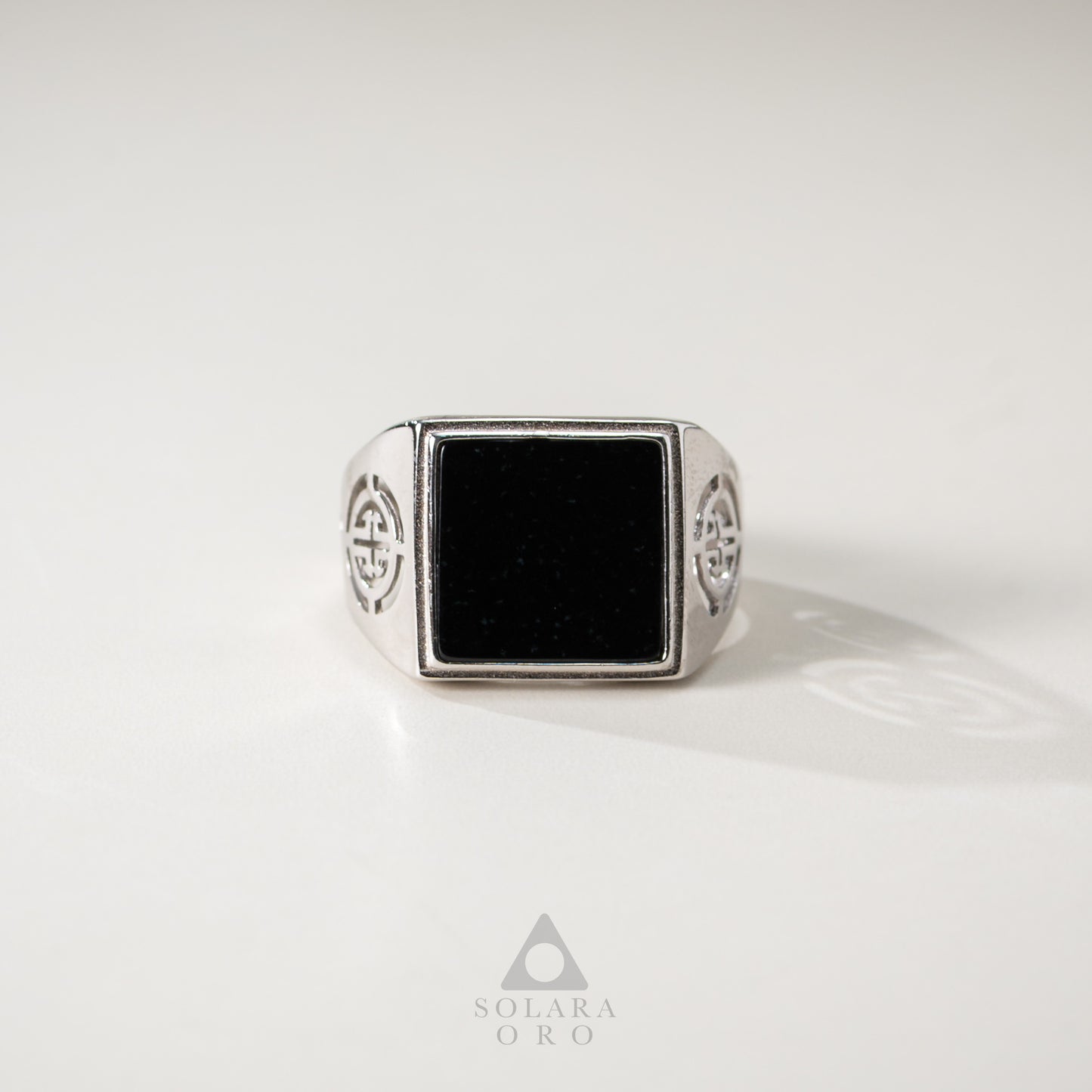 Silver ring with a black square stone on a white background, branded 'Soleara Oro'.