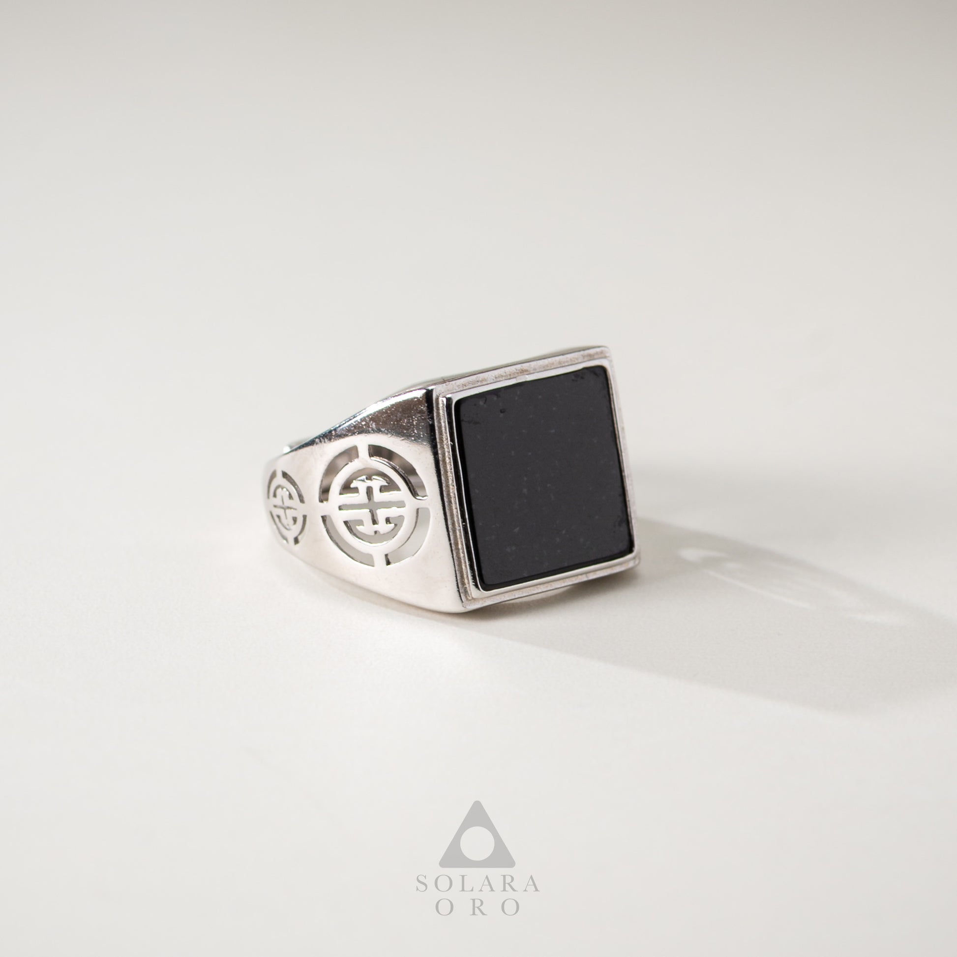 Silver ring with black stone on a white background, featuring the Solara Oro brand.