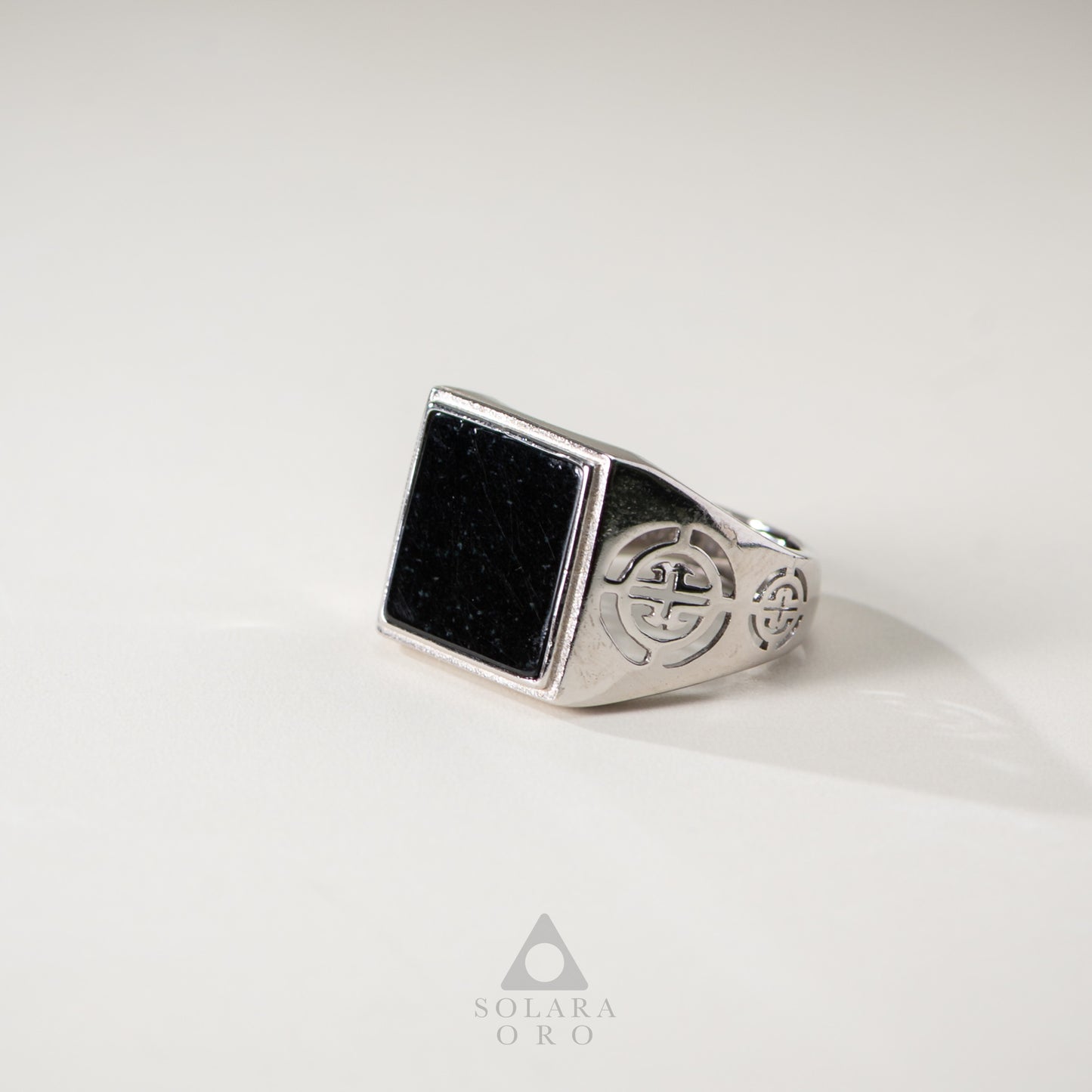 Silver ring with black stone on a white background, featuring the brand 'Solara Oro'.
