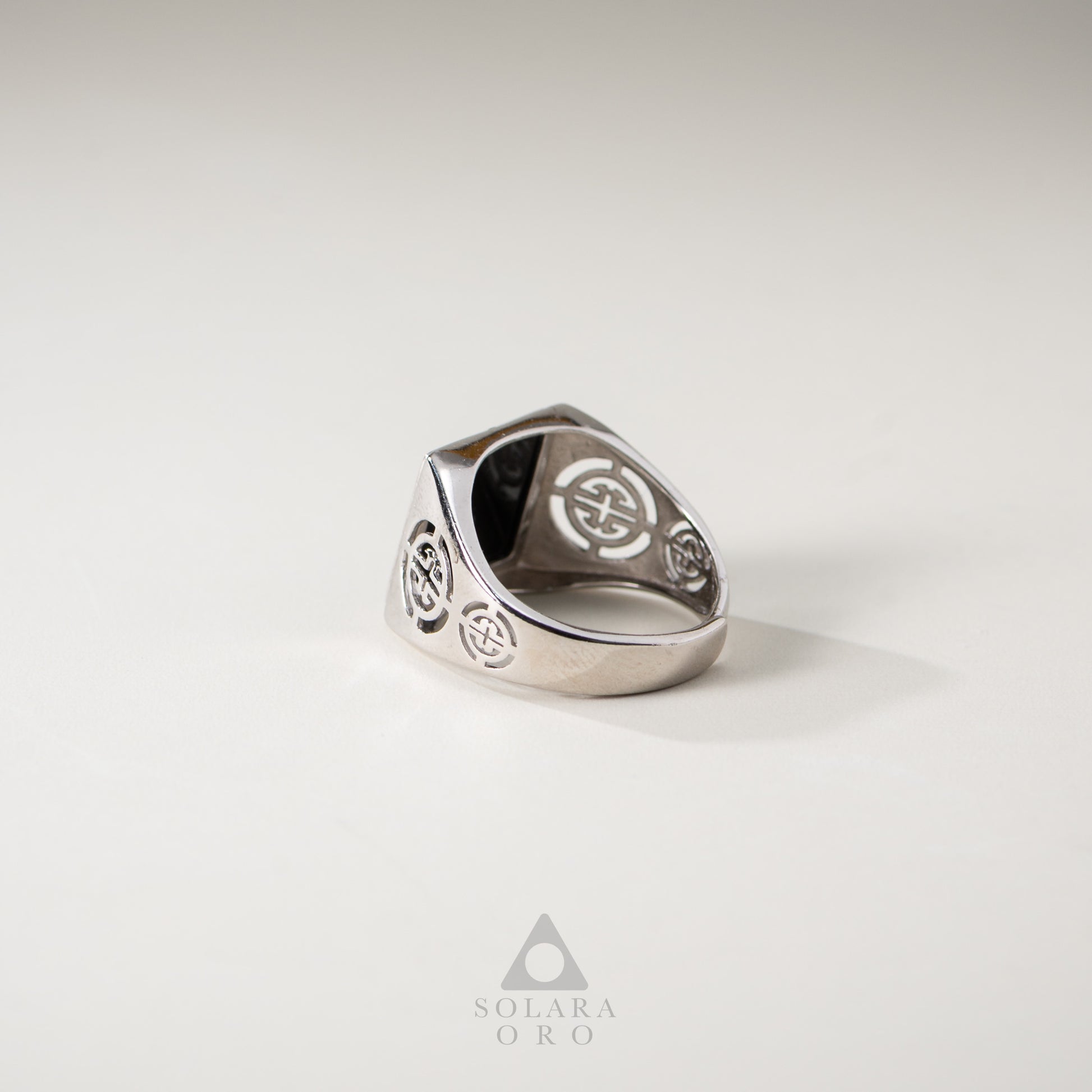 Silver ring with engraved design on a light gray background, featuring the brand 'Soleara Oro'.