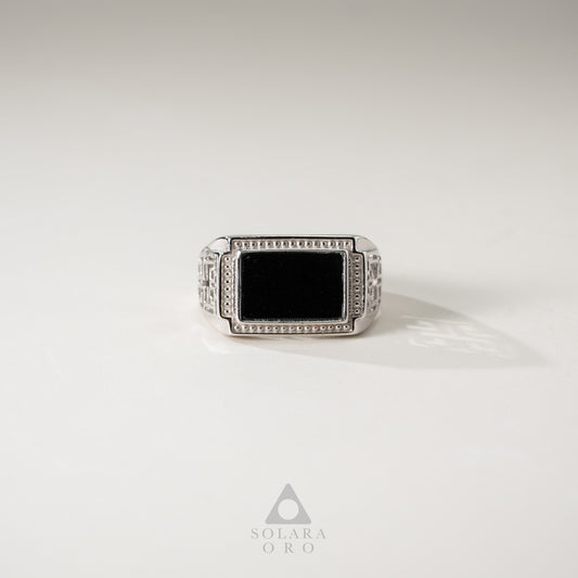 Silver ring with a black stone on a white background, featuring the Solara Oro logo.