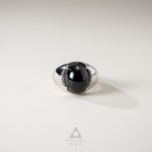 Silver ring with a black gemstone on a light gray background, featuring the brand 'Solara Oro'.