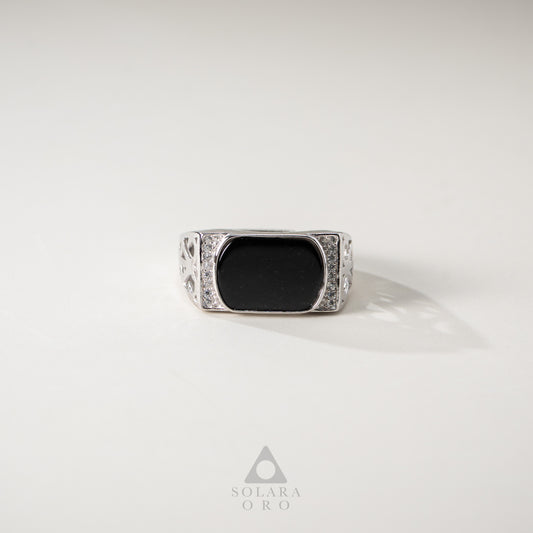 Silver ring with a black stone on a white background, featuring the Solara Oro logo.
