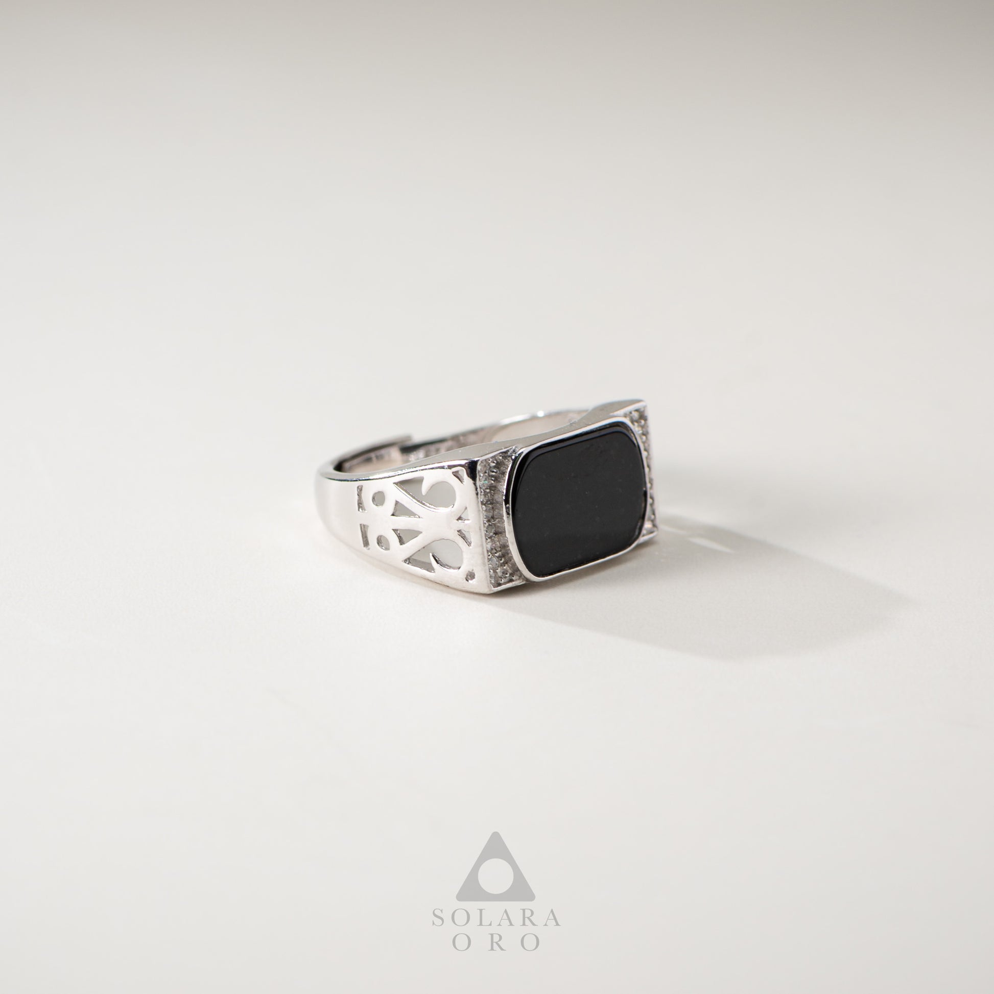 Silver ring with a black stone on a light gray background, featuring the brand 'Soleara Oro'.