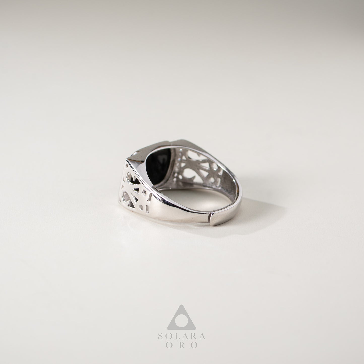 Silver ring with a black stone on a light gray background, featuring the brand 'Solara Oro'.