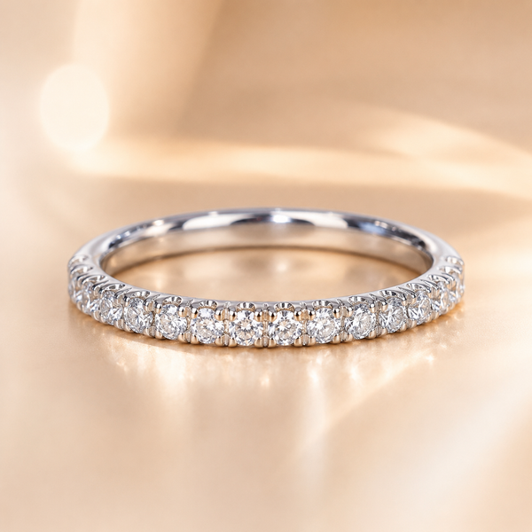 White gold pavé diamond half-eternity band, front view on a beige background