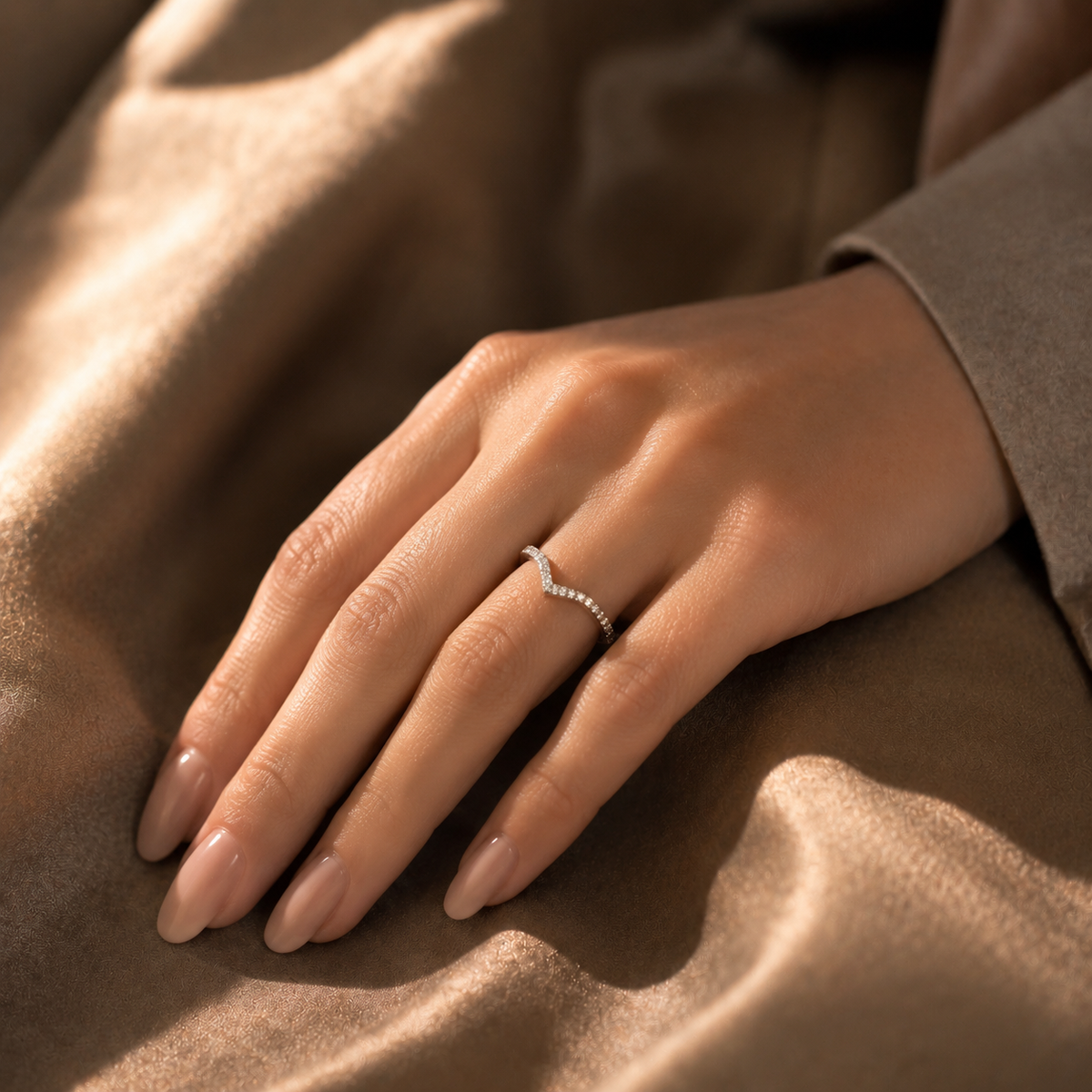 Kairos pavé diamond chevron ring worn on hand, lifestyle indoor shot