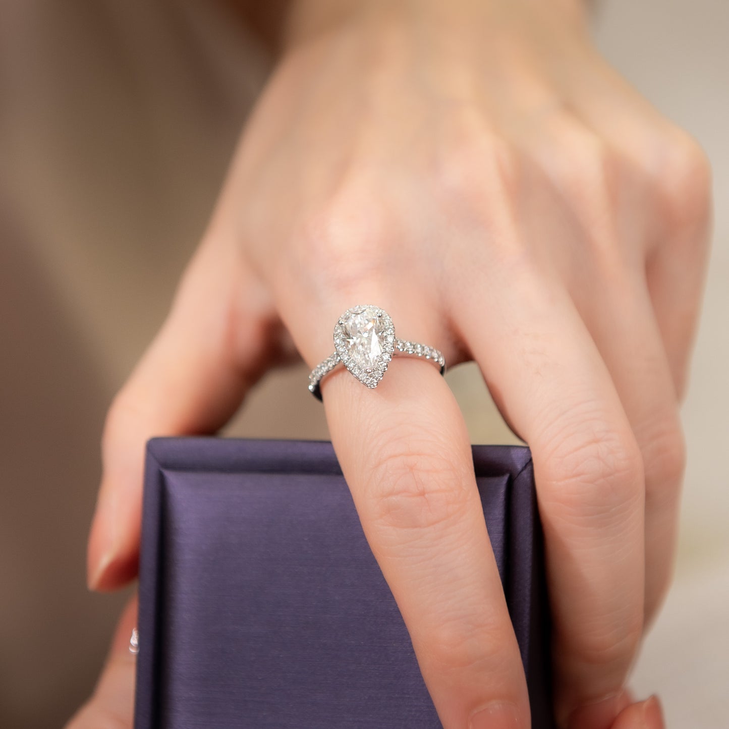 Diamond ring on a finger with a blurred background