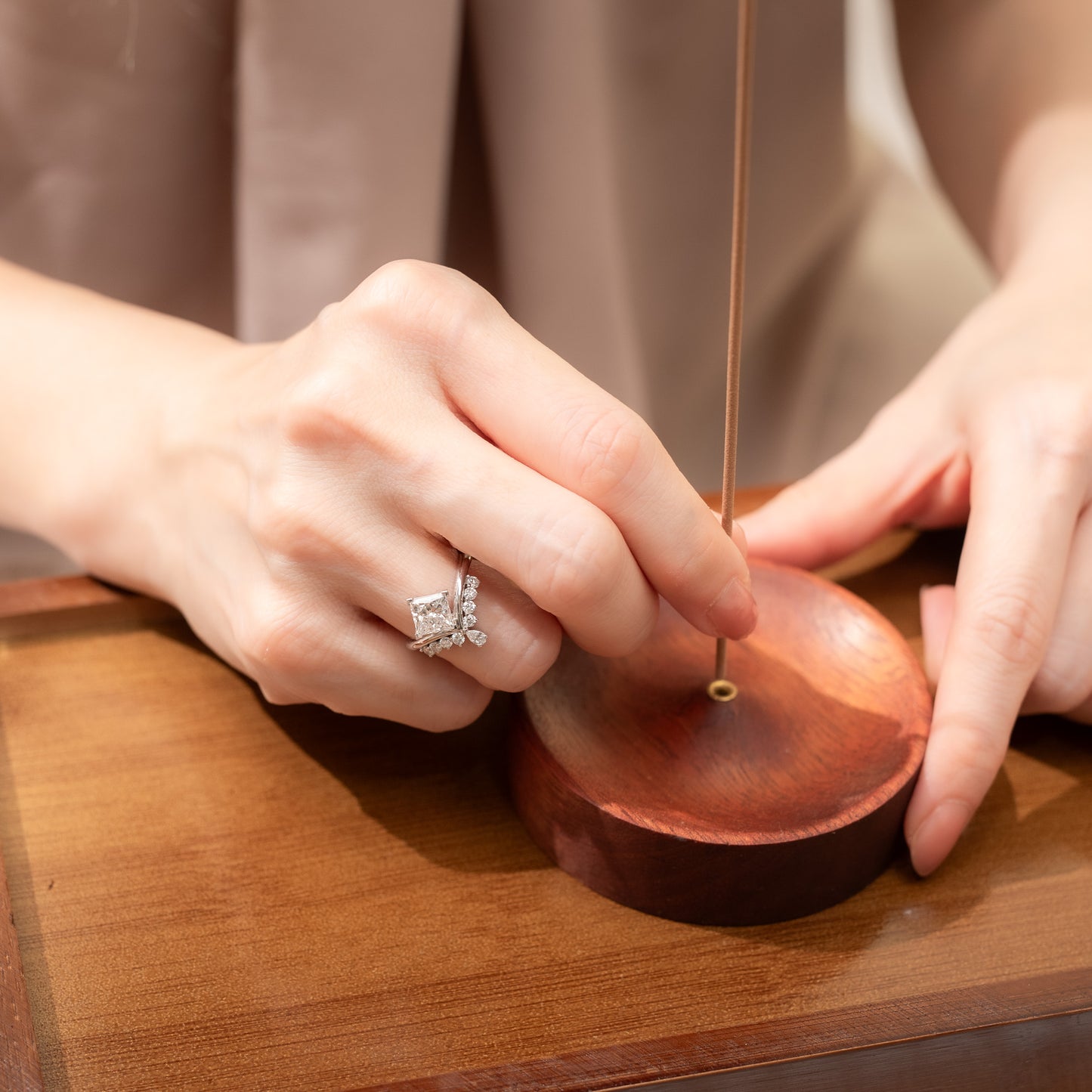 Close-up of hands tuning a guitar on a wooden surface