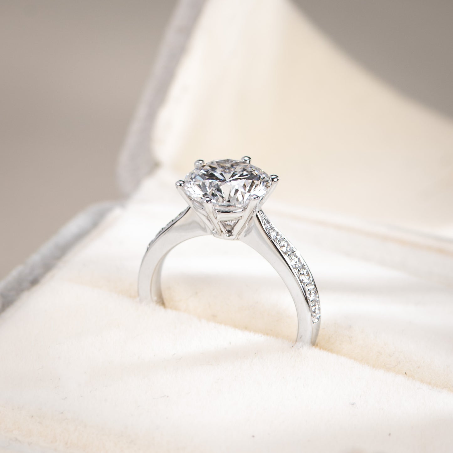 Silver ring with a large diamond on a soft, neutral background