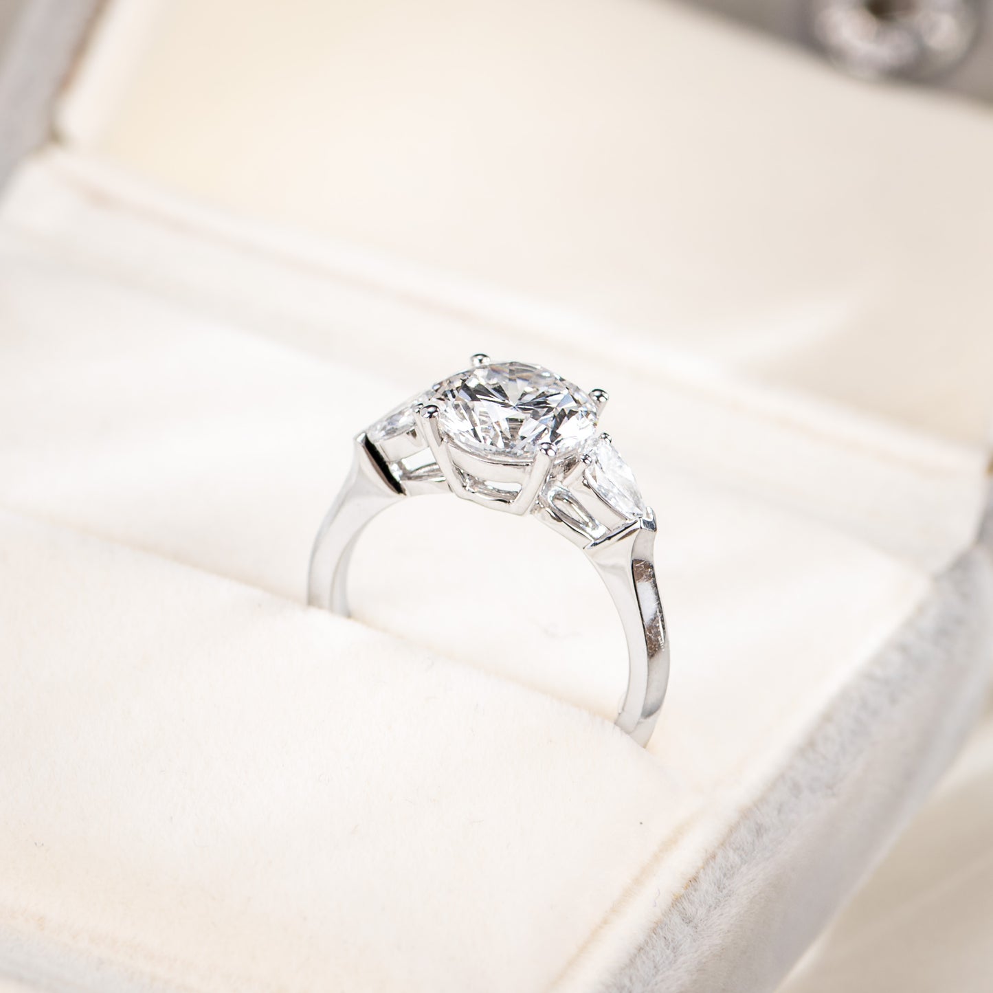 Silver ring with a large diamond on a soft white background
