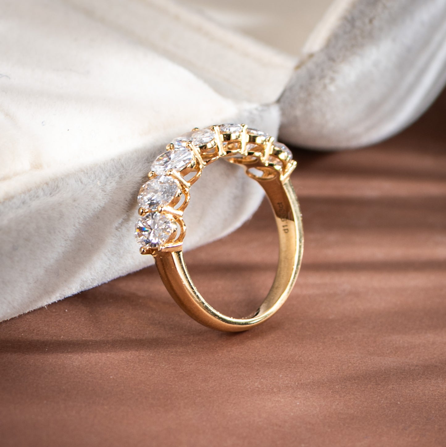 Gold ring with diamonds on a soft fabric background