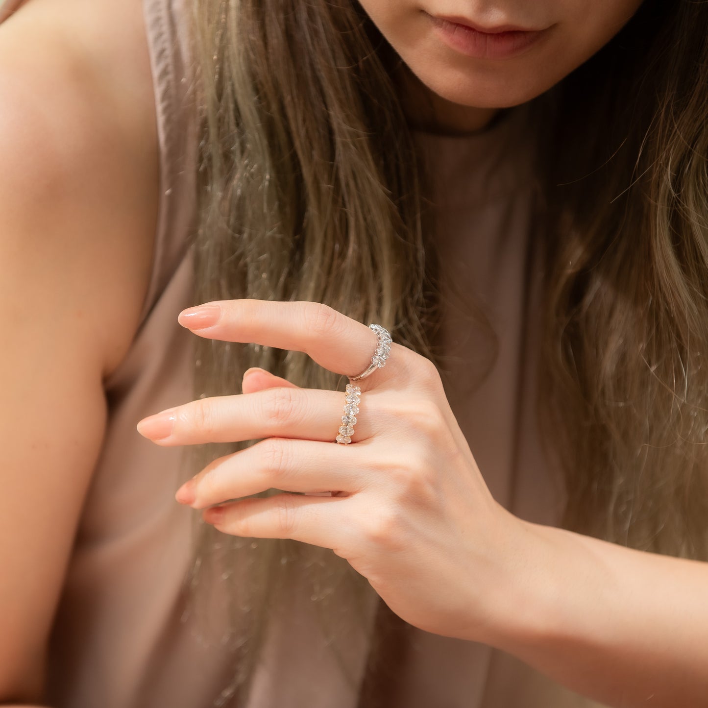 Close-up of a hand wearing a diamond ring with a soft focus background